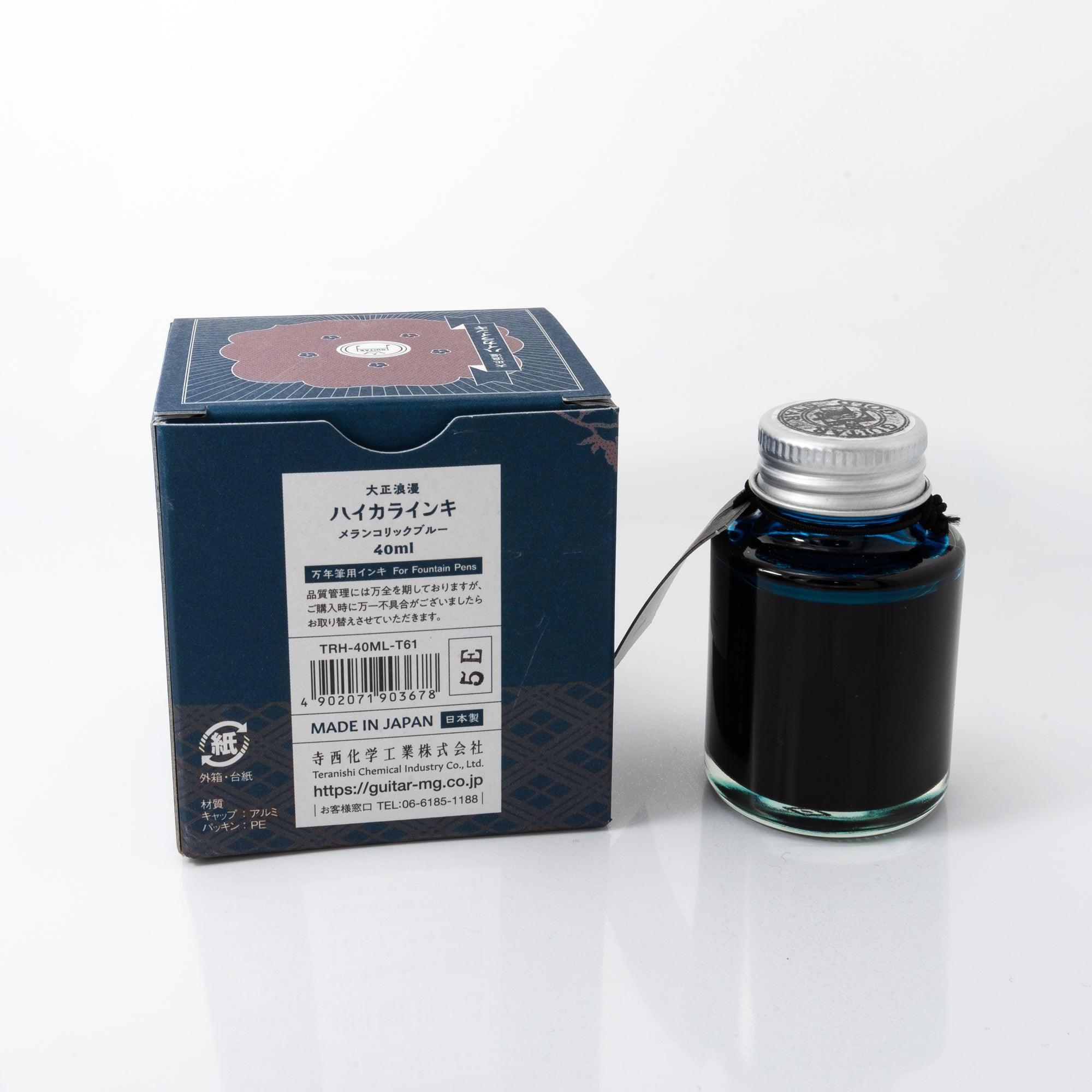 Top view of the Taisho Romance Melancholic Blue ink bottle, showcasing its striking blue ink, surrounded by warm wooden textures.