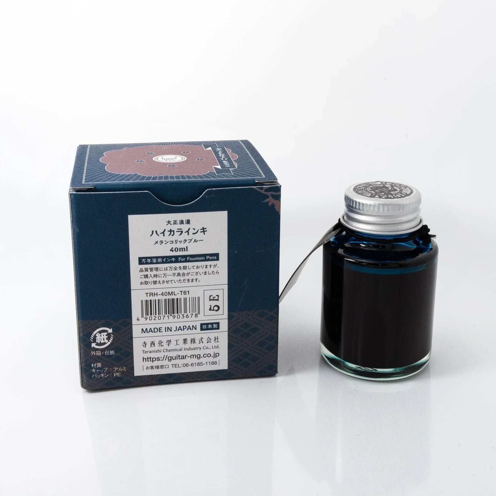 Taisho Romance Melancholic Blue ink bottle with Japanese calligraphy brush and stationery on styled surface detail