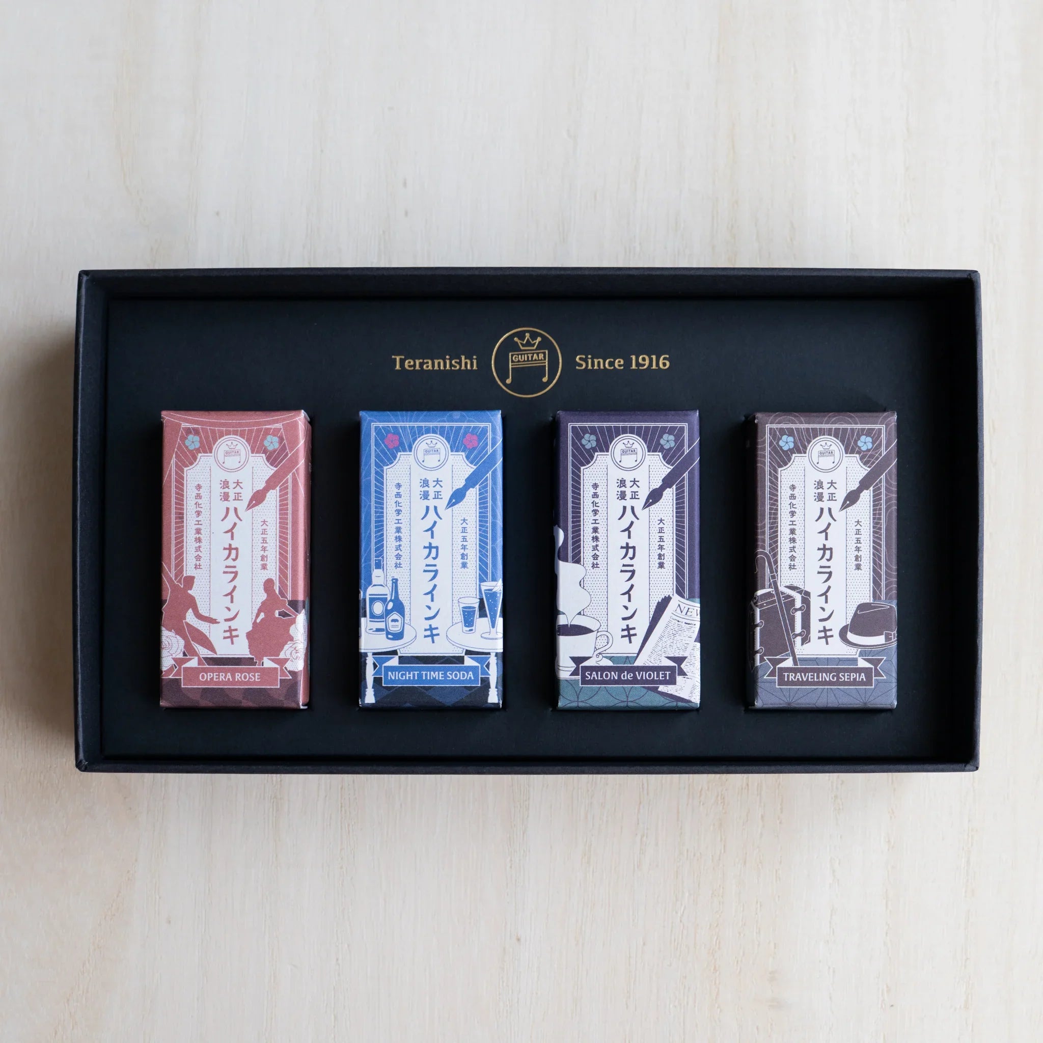 Open black gift box of the HAIKARA Metropolis set with four individually wrapped 12 ml ink bottles inside