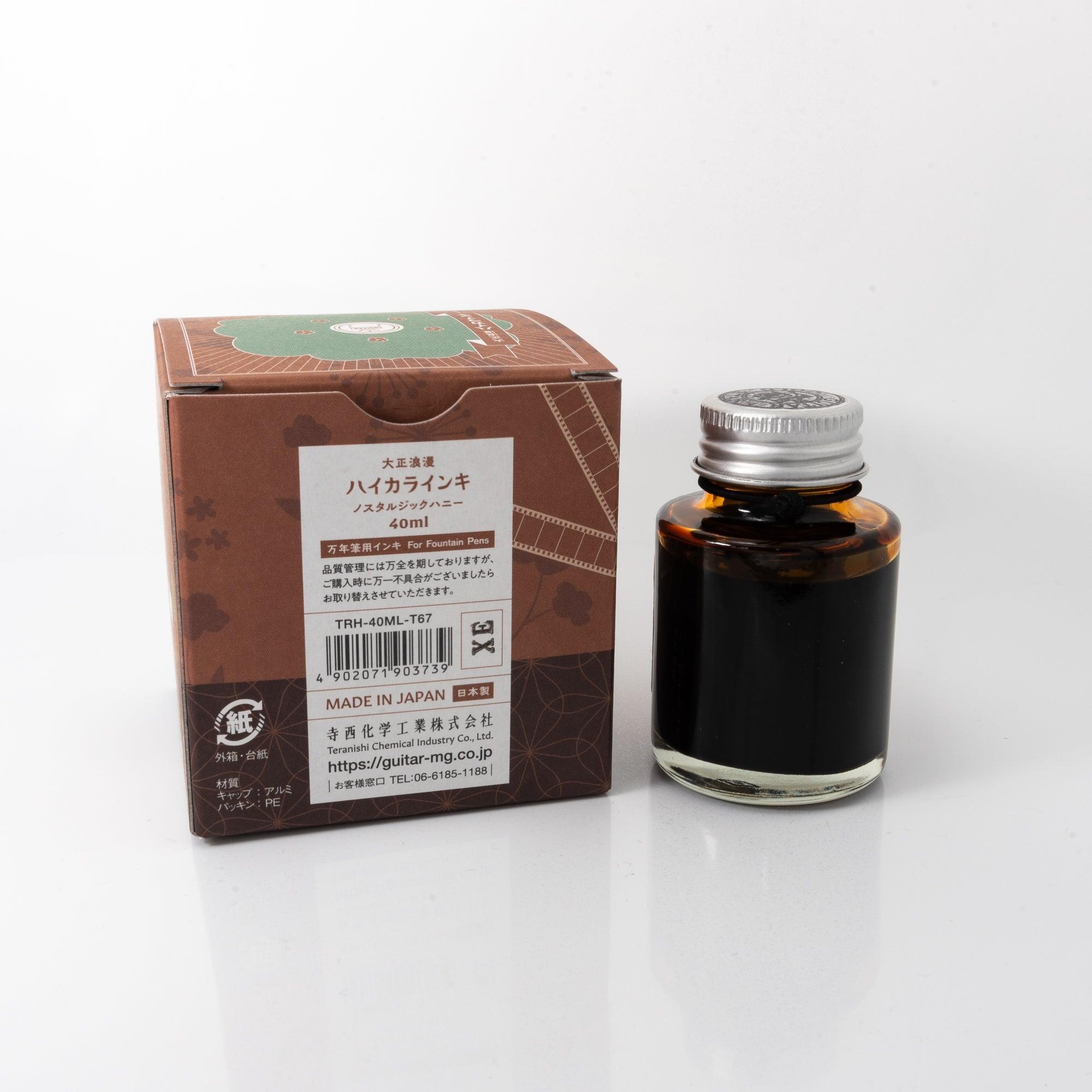 A bottle of brown-toned ink "NOSTALGIC HONEY" with its box showing detailed product information, a Japanese stationery item.