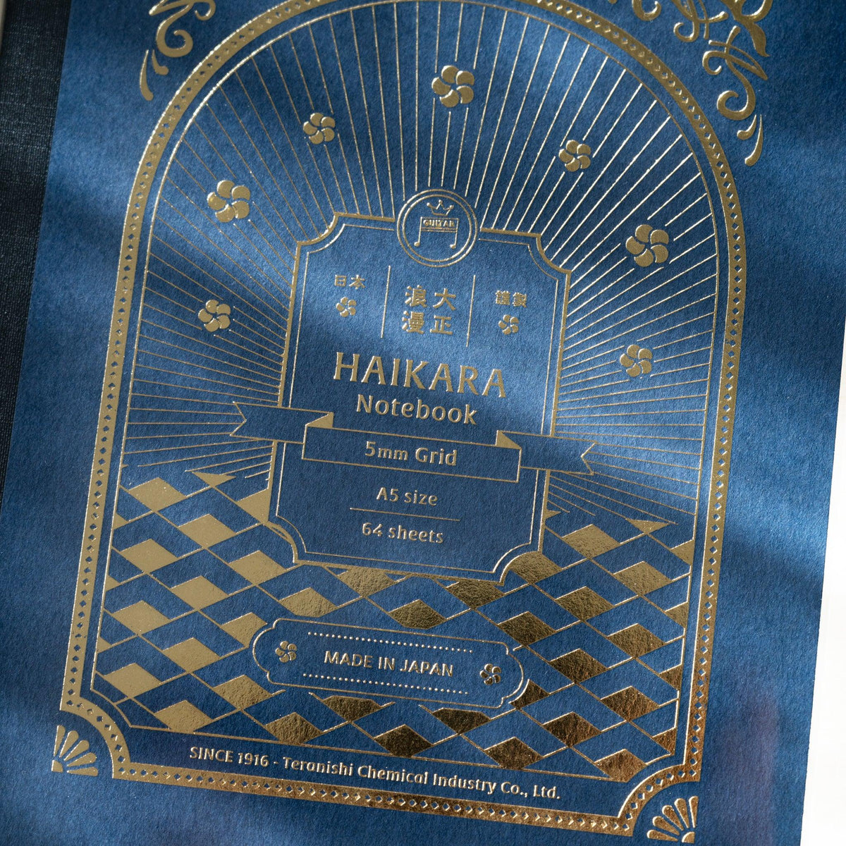 Close-up of gold foil on dark blue cover reading HAIKARA Notebook 5mm Grid A5 size 64 sheets and Made in Japan