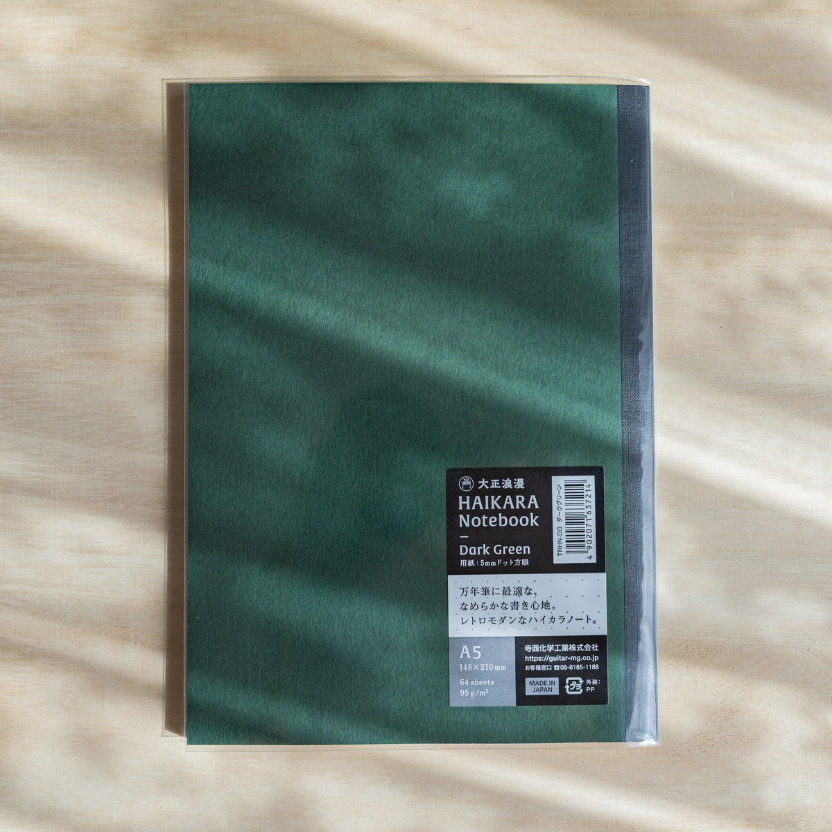 Dark green HAIKARA notebook in a clear sleeve with a black label reading Dark Green, A5, 64 sheets, 95 gsm, Made in Japan