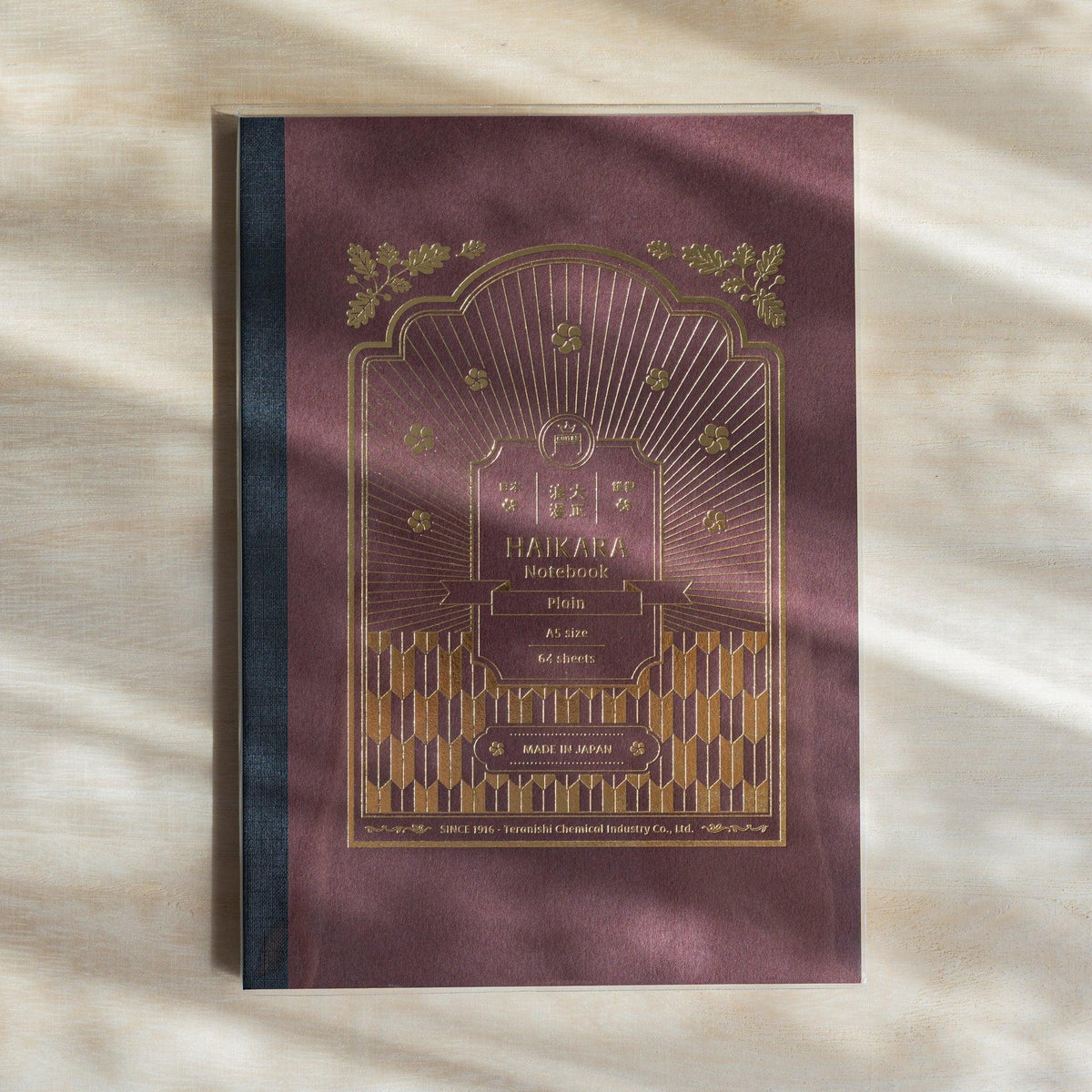 Dark red HAIKARA notebook cover with gold foil arch frame, flower motifs and arrow pattern, dark cloth spine tape