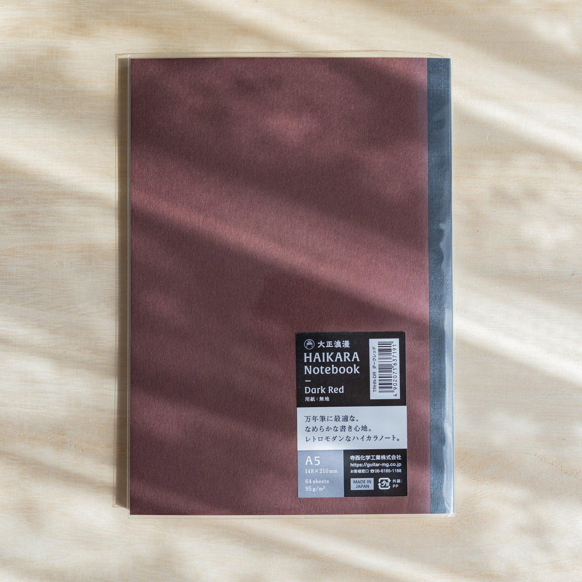 Dark red HAIKARA notebook in a clear sleeve with a black label reading Dark Red, A5, 64 sheets, 95 gsm, Made in Japan