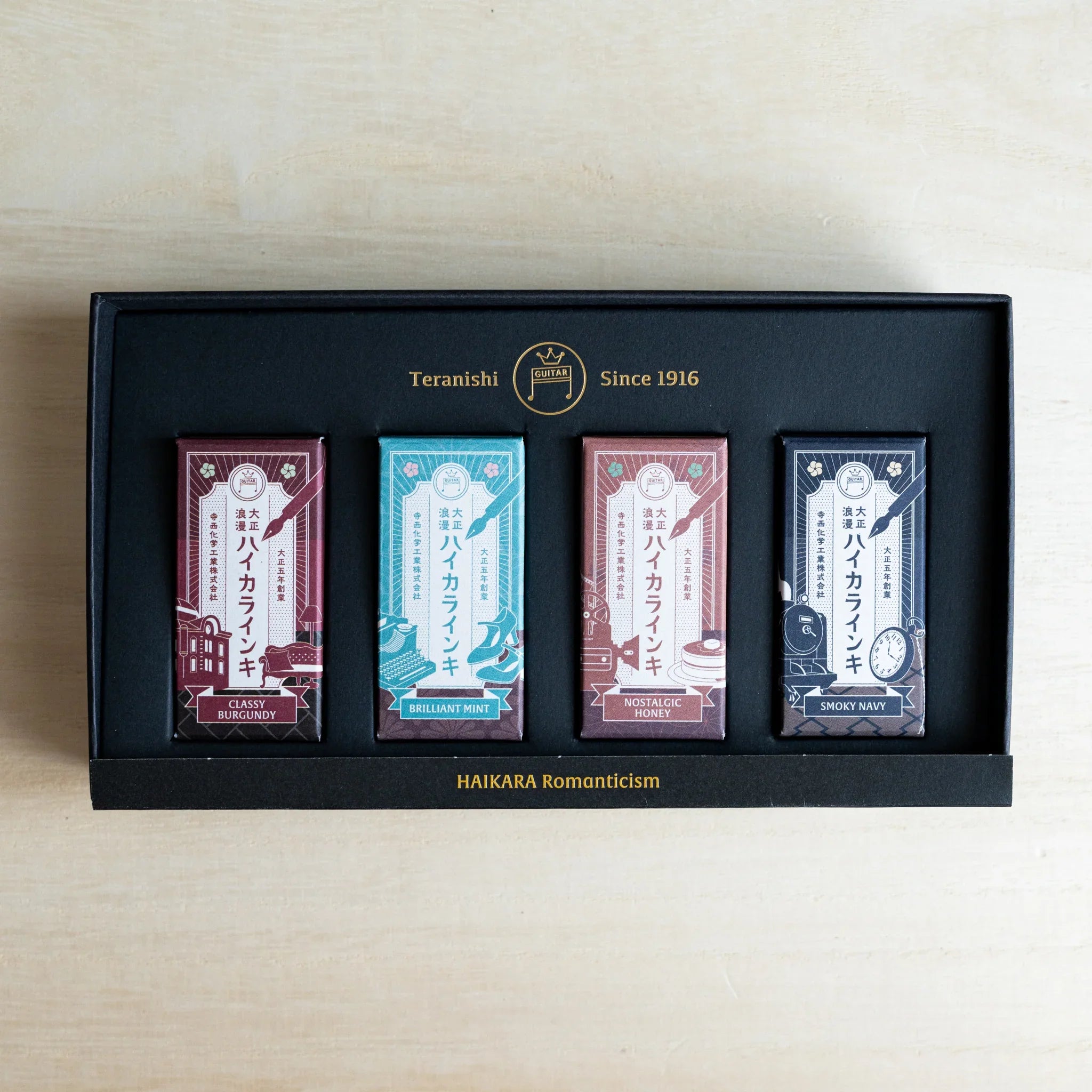 Open black gift box of the HAIKARA Romanticism set with four individually wrapped 12 ml ink bottles inside