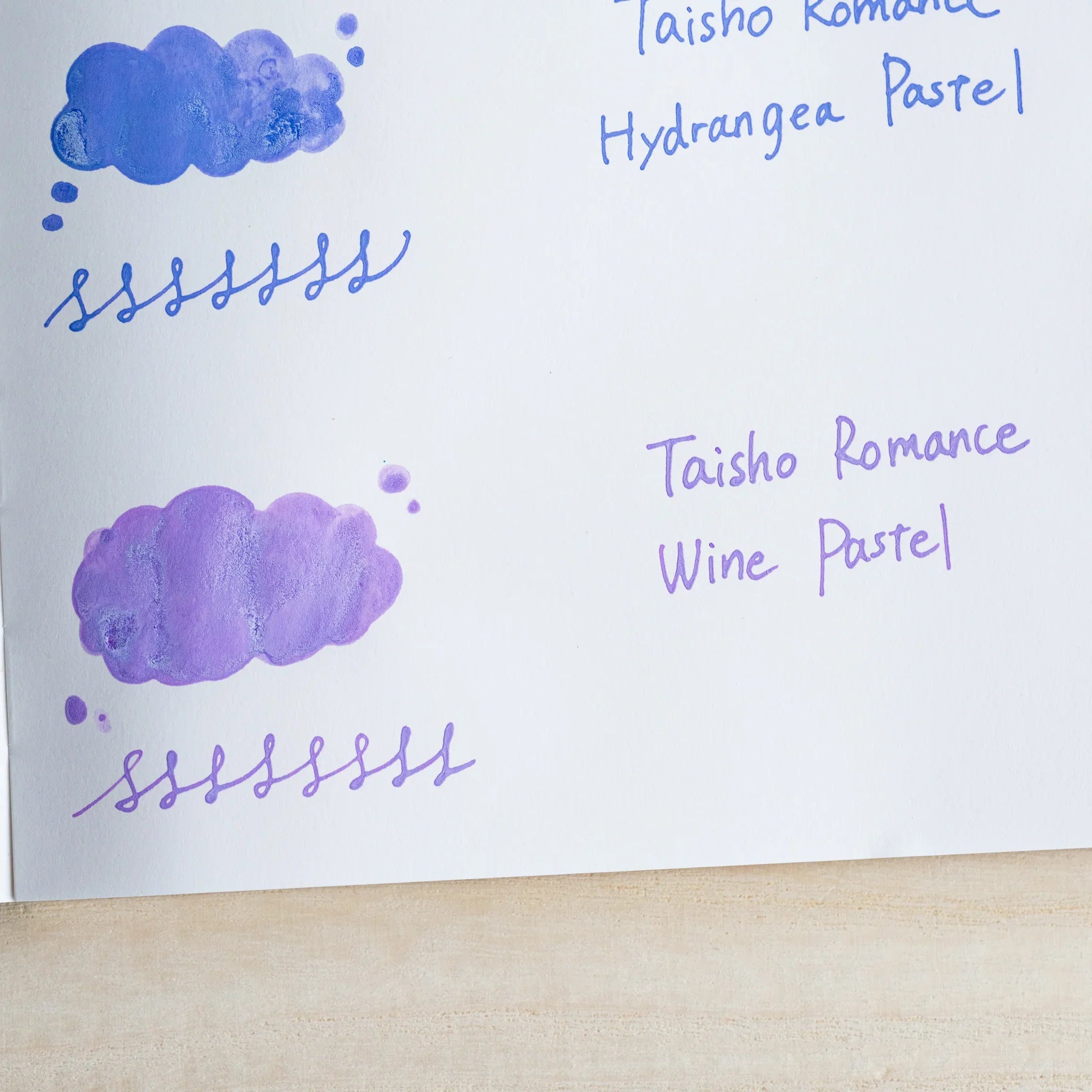 Handwritten swatch of Taisho Romance Wine Pastel ink, a cloud-shaped wash and a looped line in purple