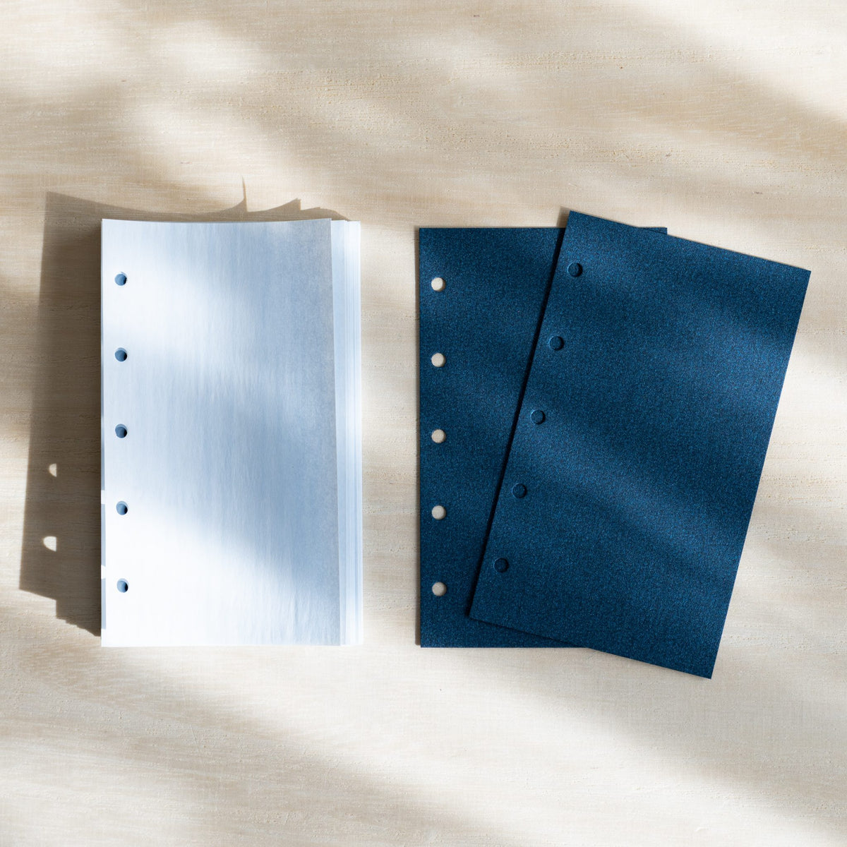 Stack of pale blue KateJo Onion Skin M5 sheets beside two dark blue lifter sheets