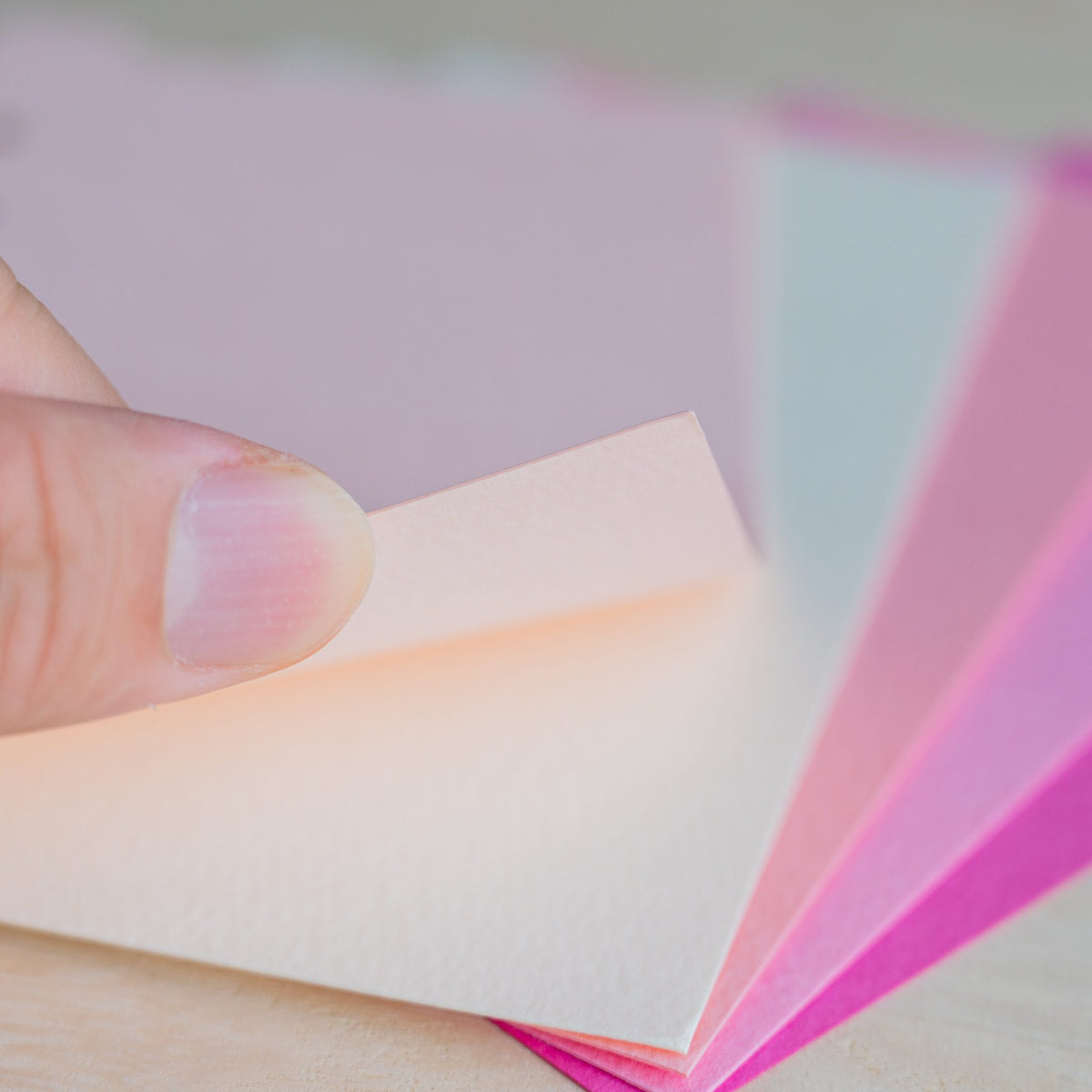 Fingertip lifting a coral Mermaid divider corner over bright pink sheets
