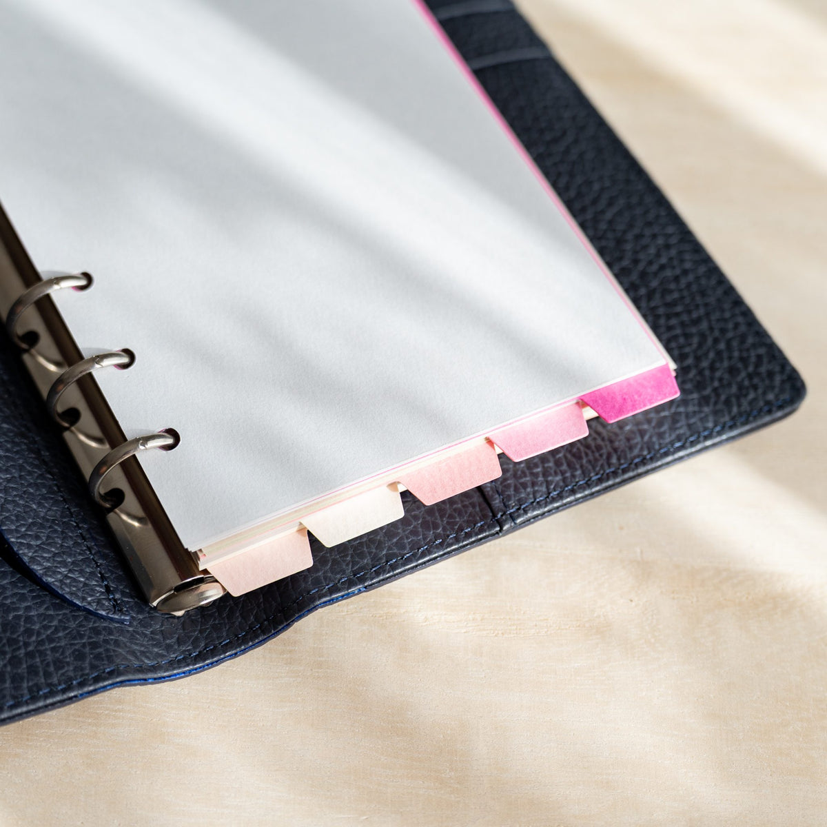 Mermaid Bible dividers in a navy planner with staggered pink and white top tabs at the edge