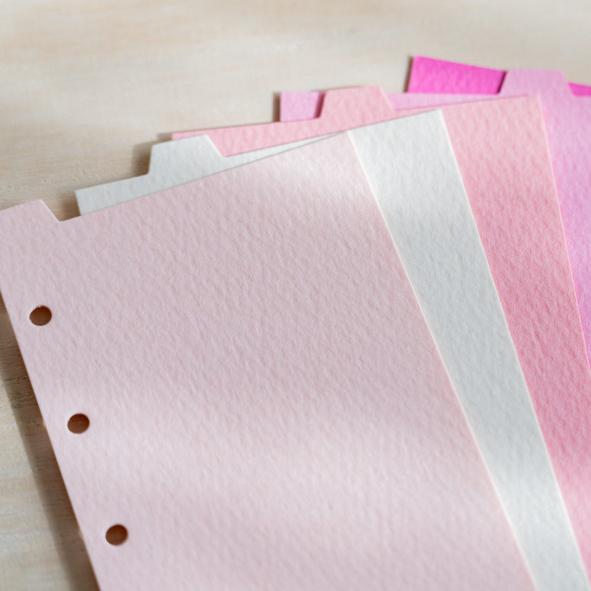 Close-up of Mermaid M5 pink dividers showing the rippled felt-mark texture and punched holes