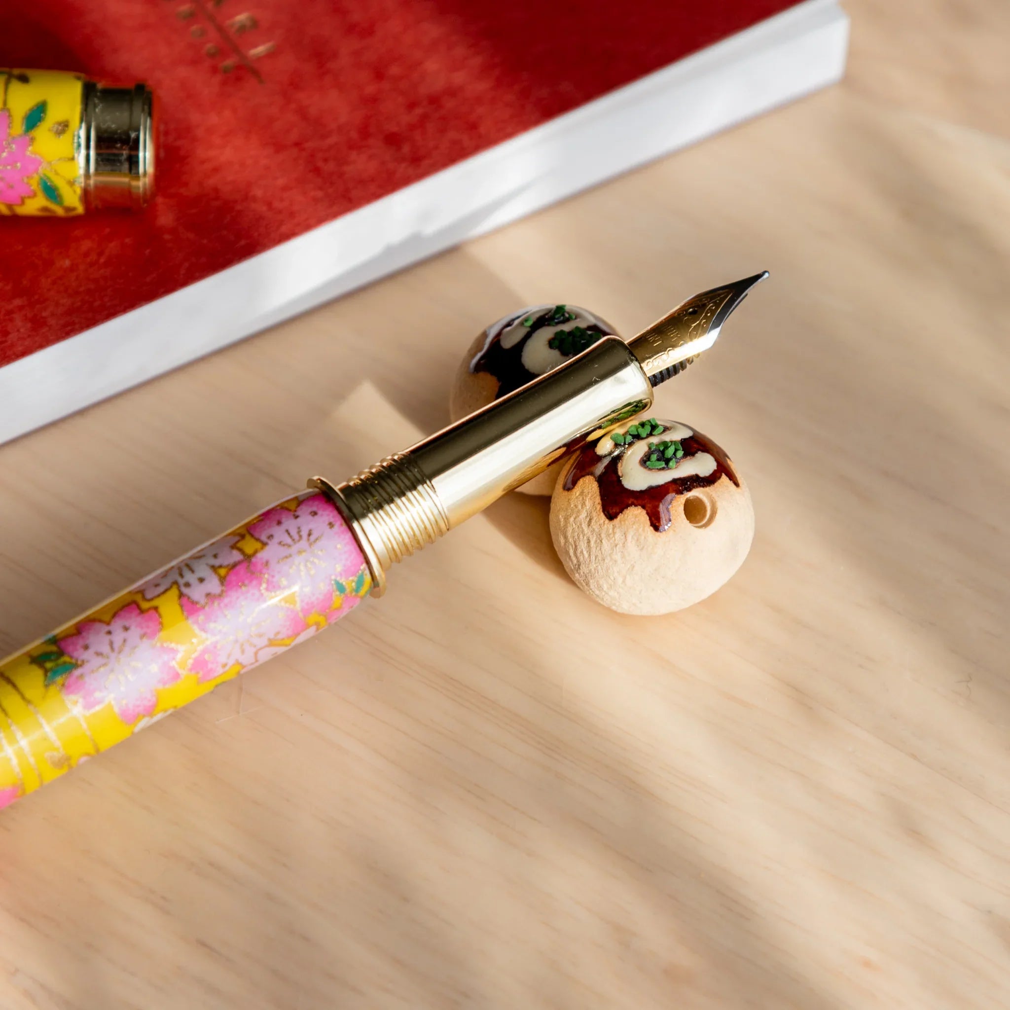 Takoyaki handcrafted ceramic pen rest brown with authentic spherical Japanese octopus ball design form close shot