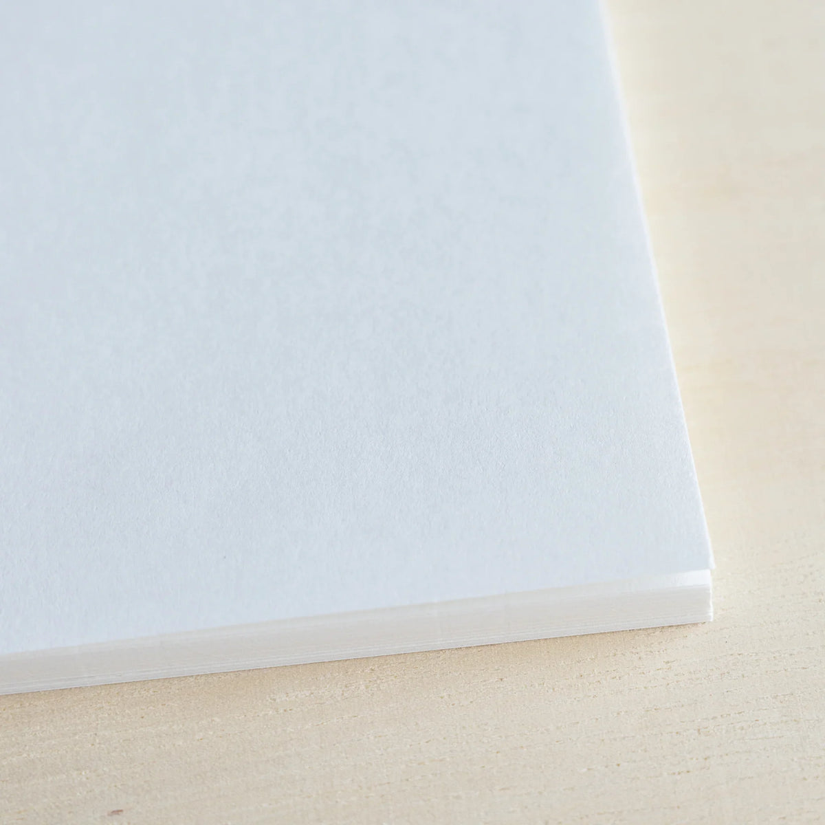 Close-up of the corner and cut edge of the Tateyama A4 paper stack showing the smooth white surface