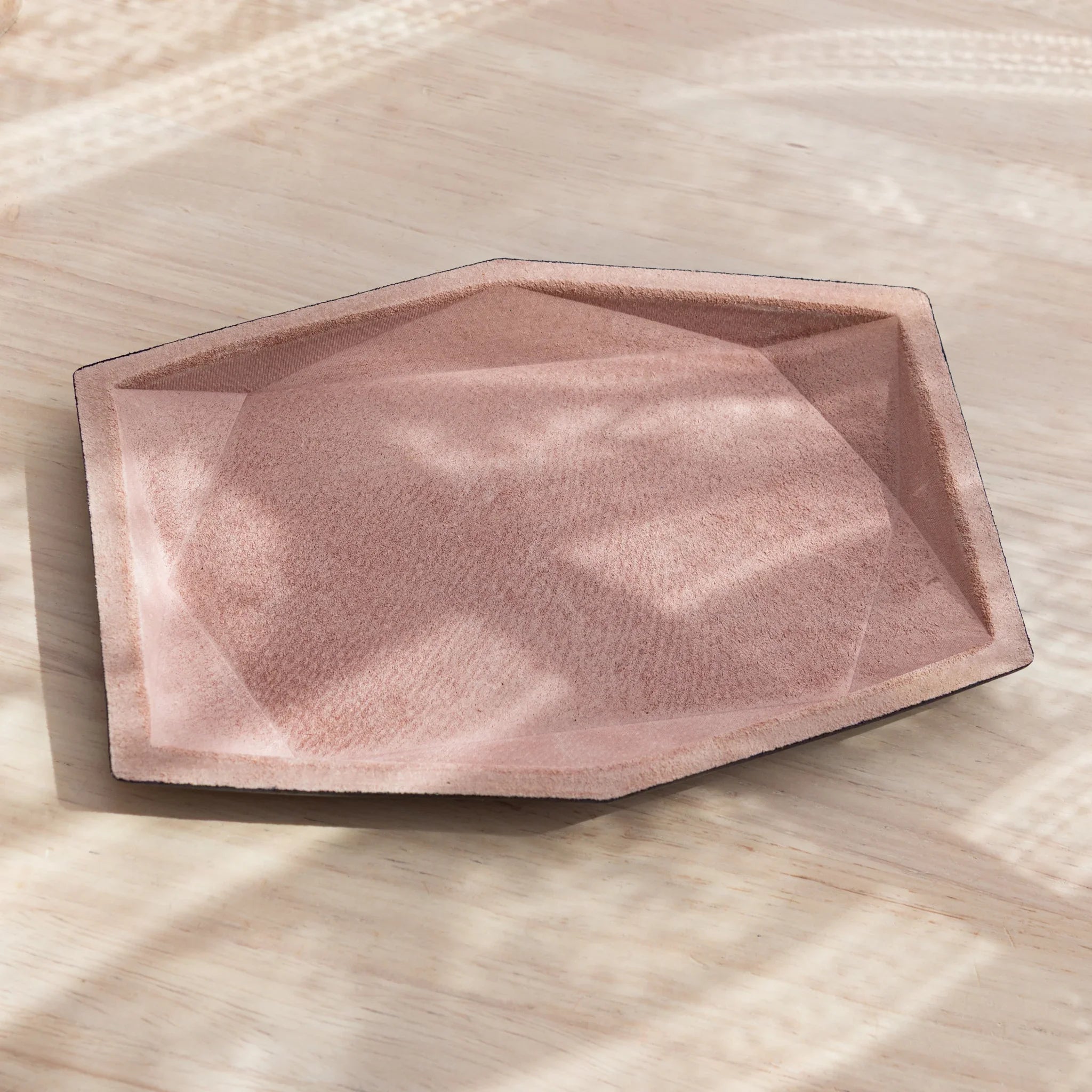 Japanese Pen Tray with pink suede interior placed on a light wooden desk.
