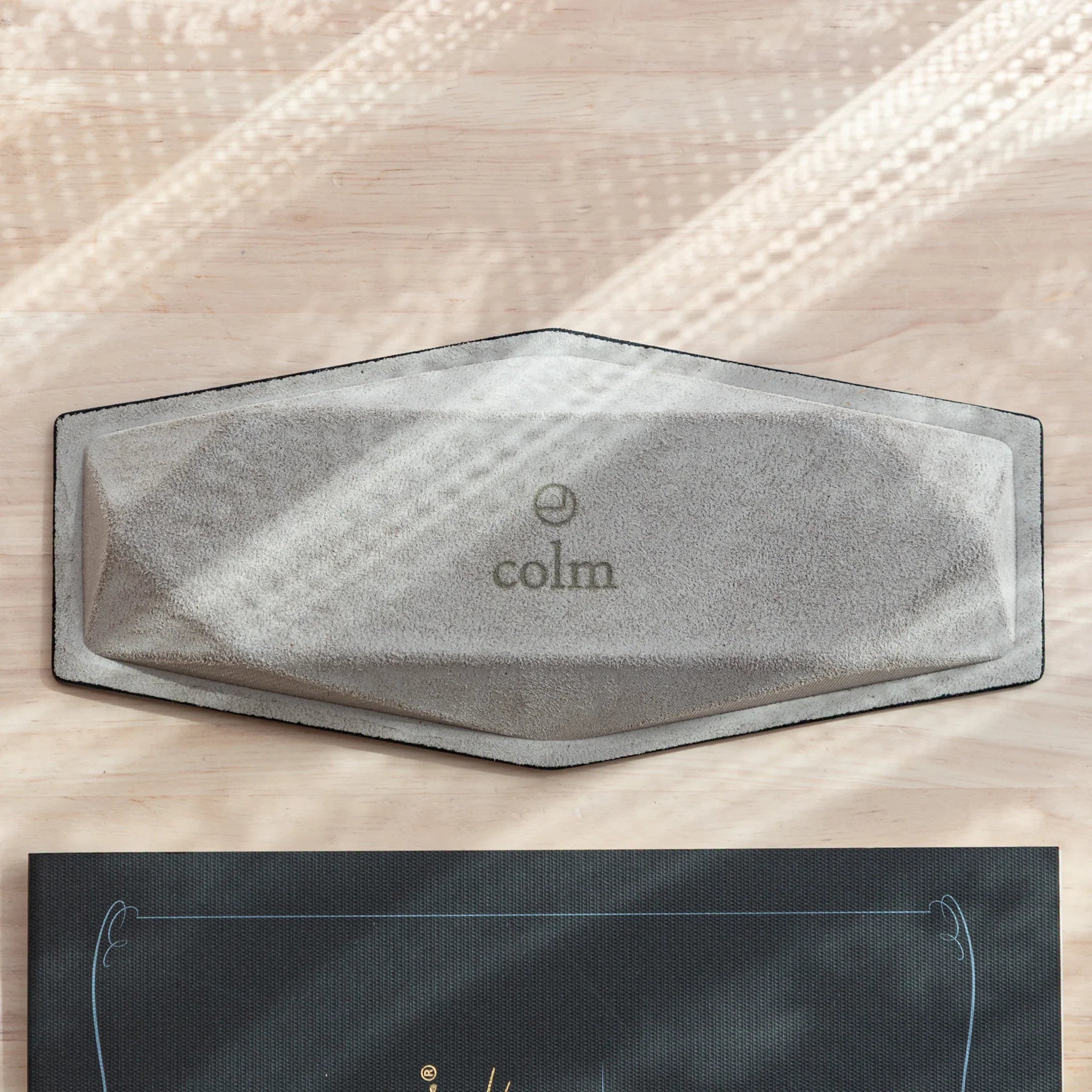Bottom of Japanese Pen Tray with colm logo on black suede.