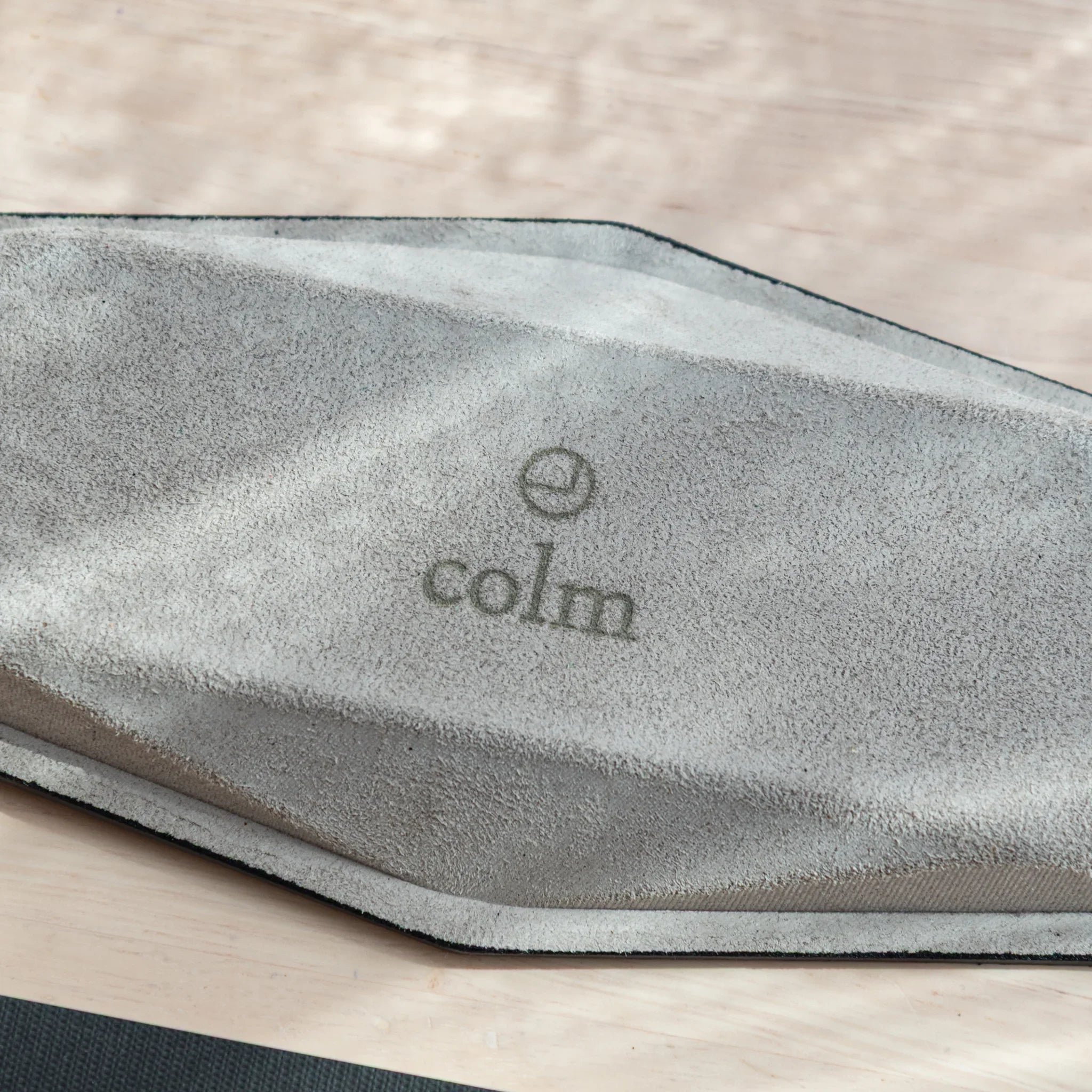 Close-up detail view of vegetable-tanned leather grain texture and natural color patina visible on pen tray exterior