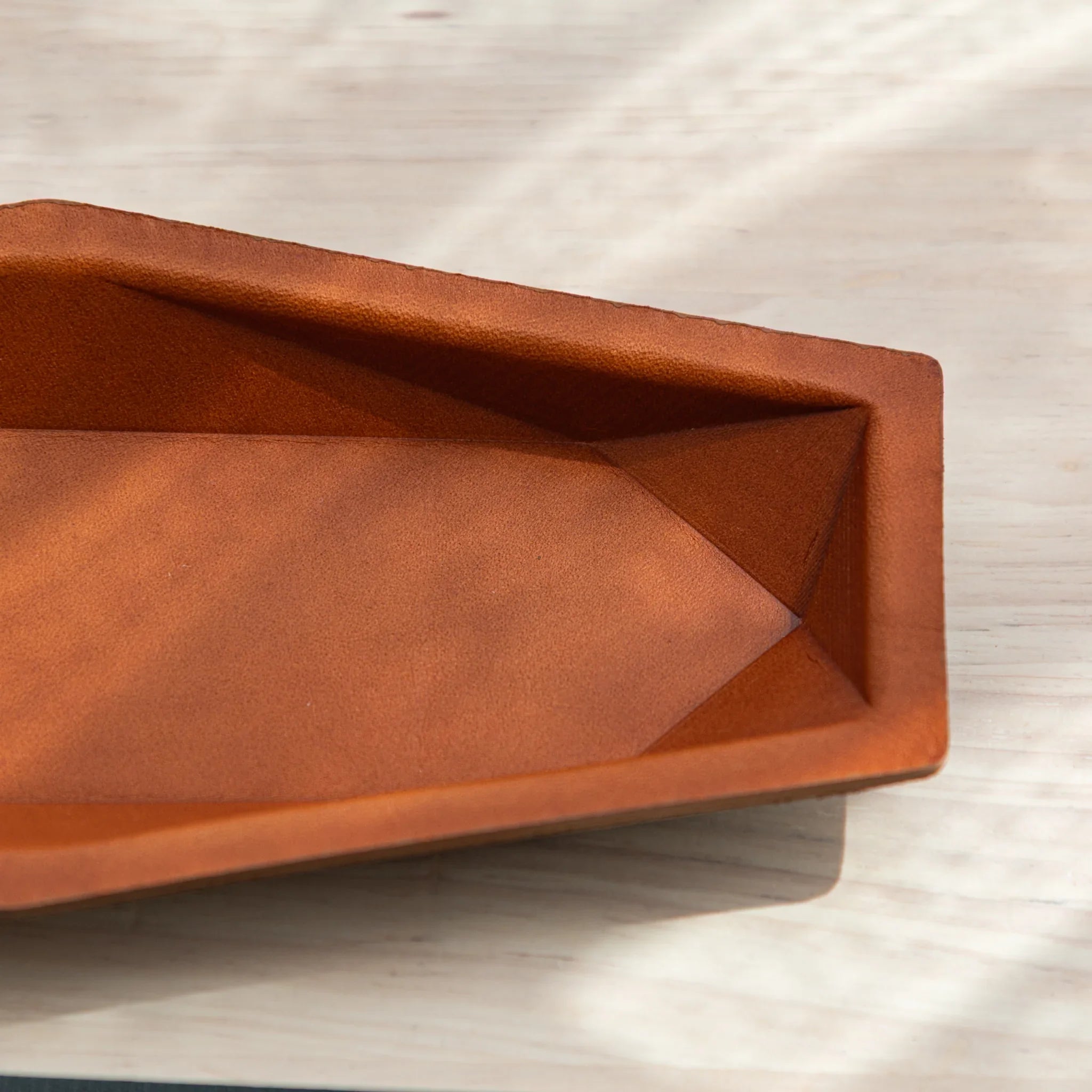 Three-quarter view positioned under natural lighting revealing leather texture details and interior compartment clearly