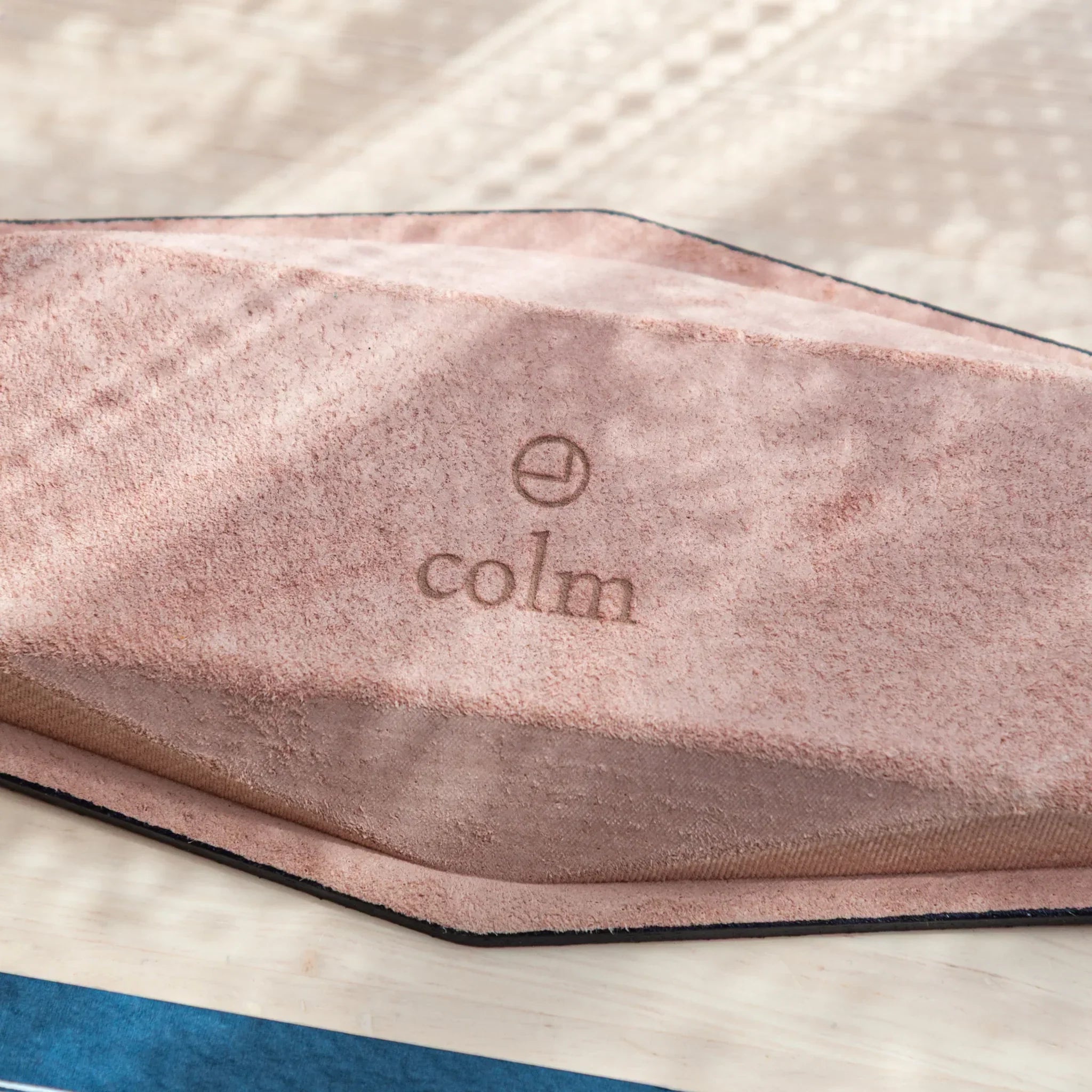 Zoomed-in view of embossed "colm" logo on suede leather base of Japanese Pen Tray.
