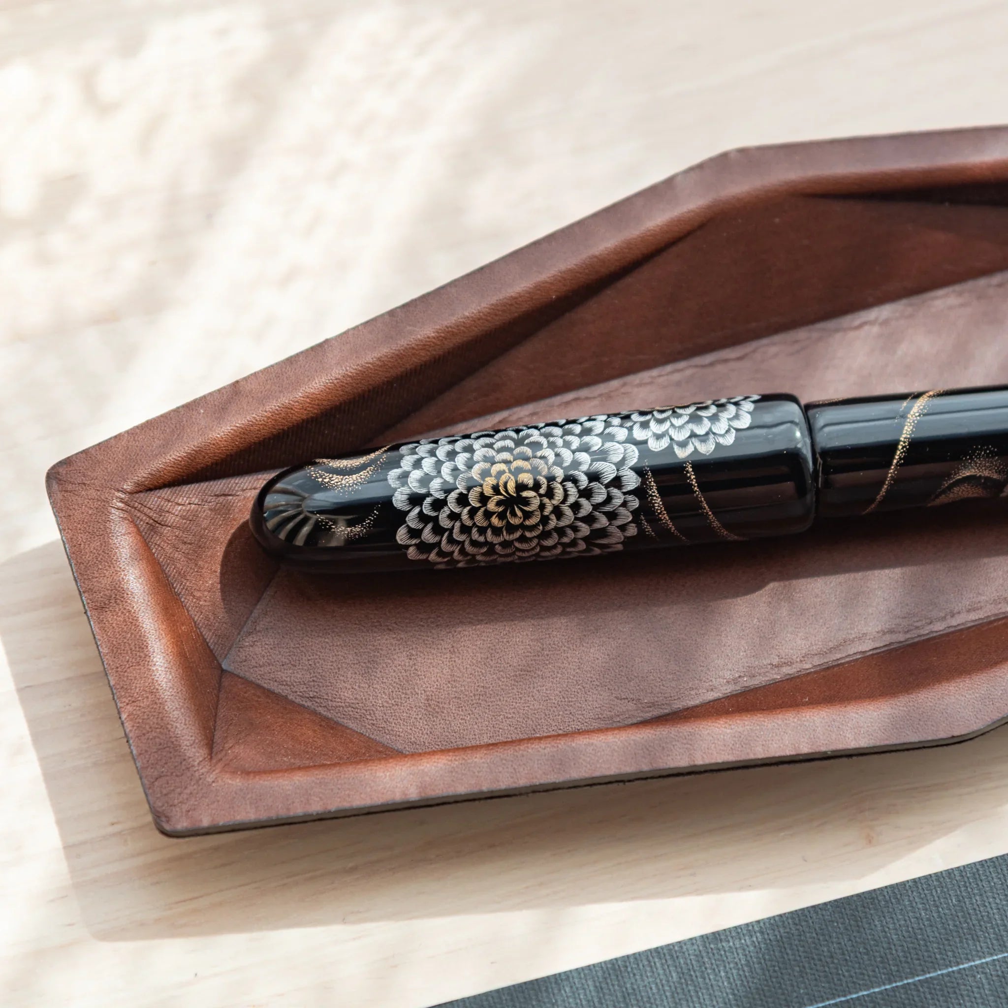 Detailed close-up view capturing leather grain patterns and hand-stitched binding edges of the hexagonal pen holder