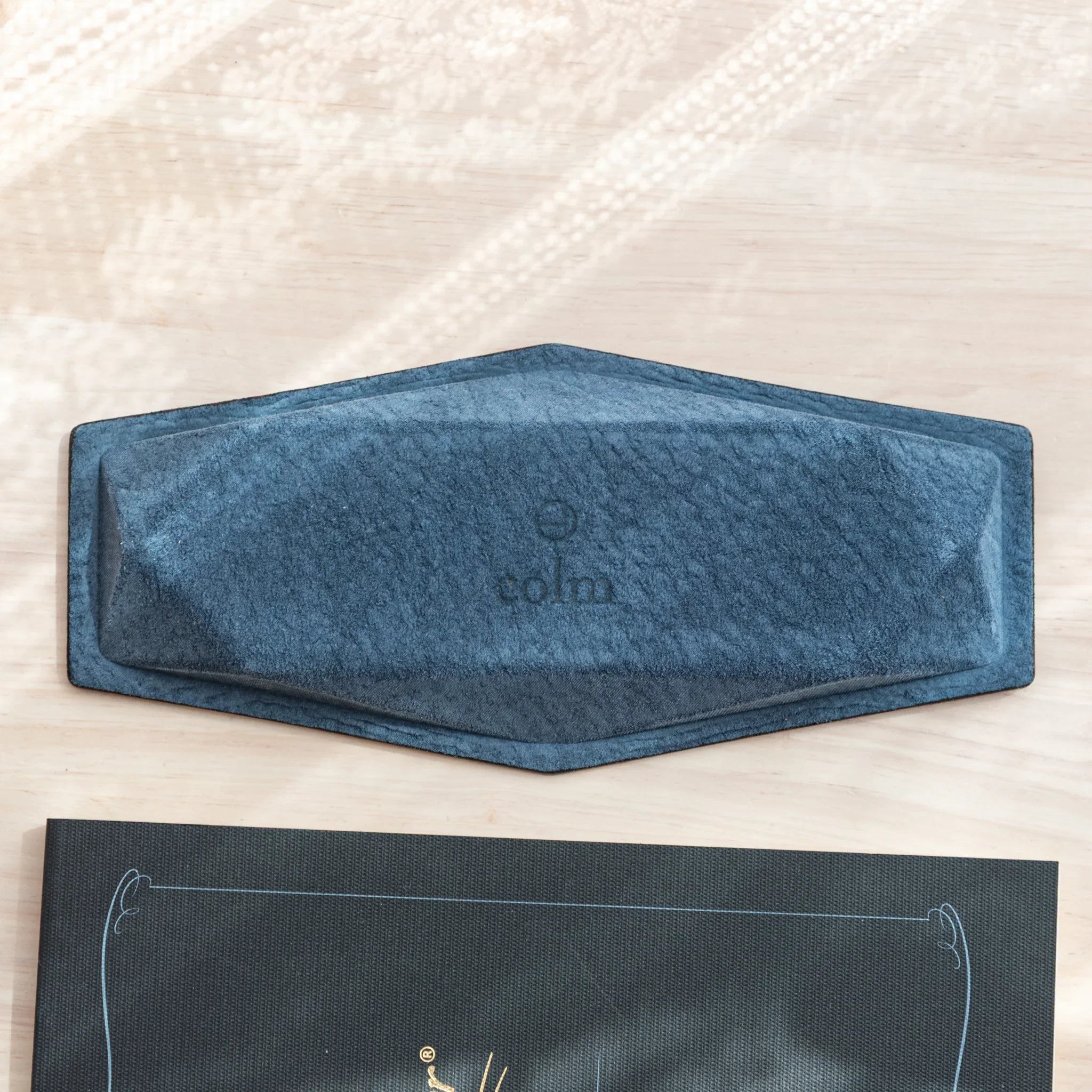 Bottom of the Japanese Pen Tray made with Teal-Blue suede and stamped with colm logo.
