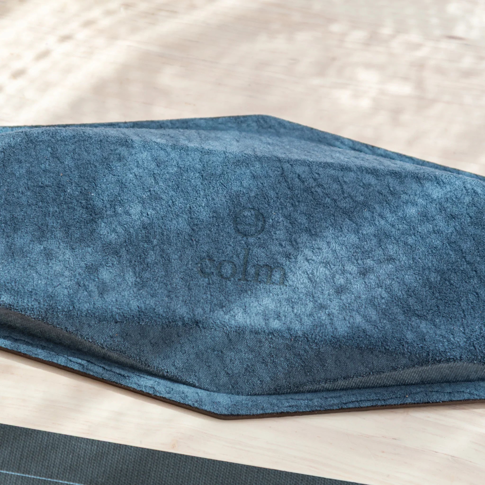 Bottom of the Japanese Pen Tray made with Teal-Blue suede and stamped with colm logo.