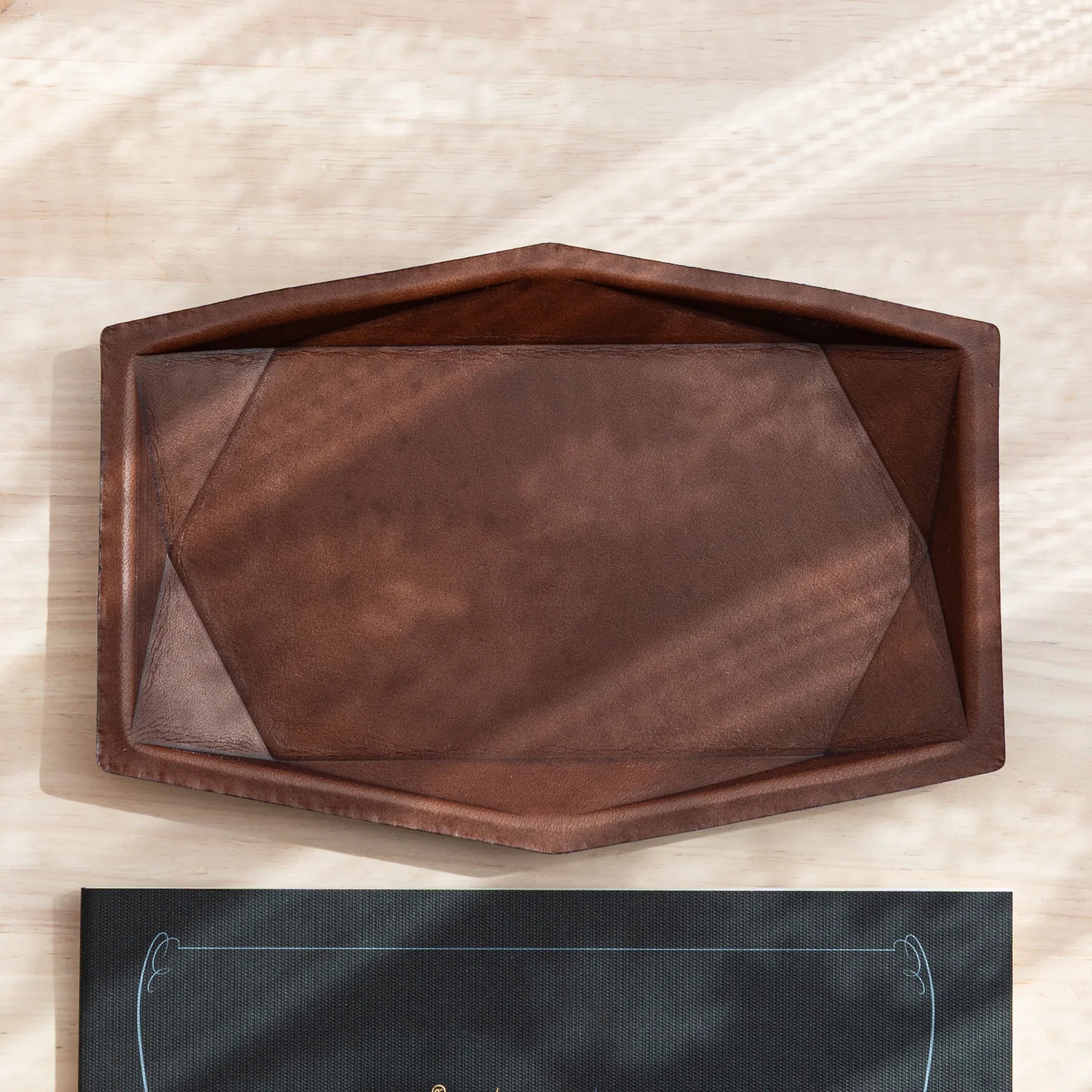Orange leather hexagonal pen tray from side displaying distinctive hexagonal profile edges and leather construction