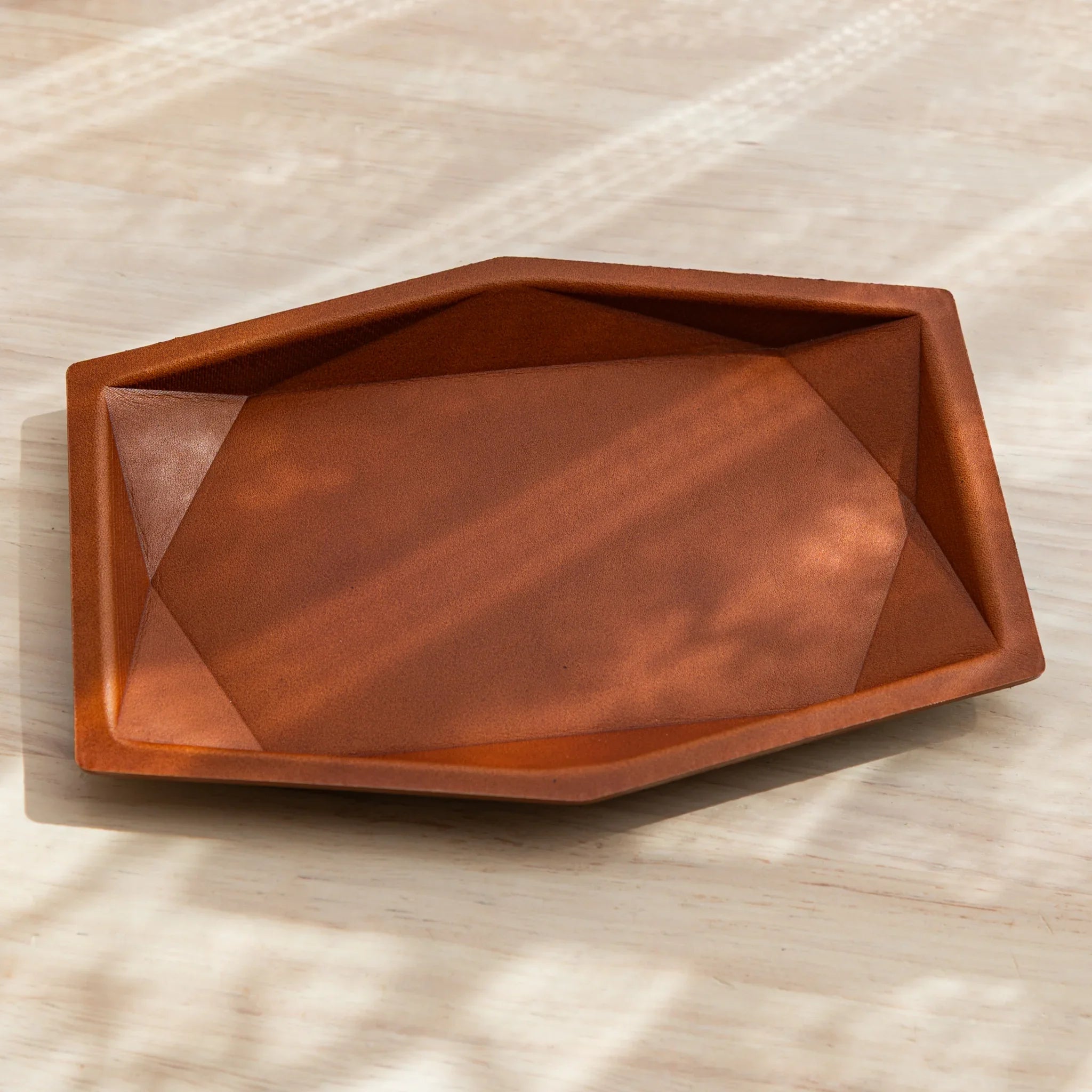 Gray hexagonal leather pen tray rear view revealing suede lining material and embossed colm brand identification logo