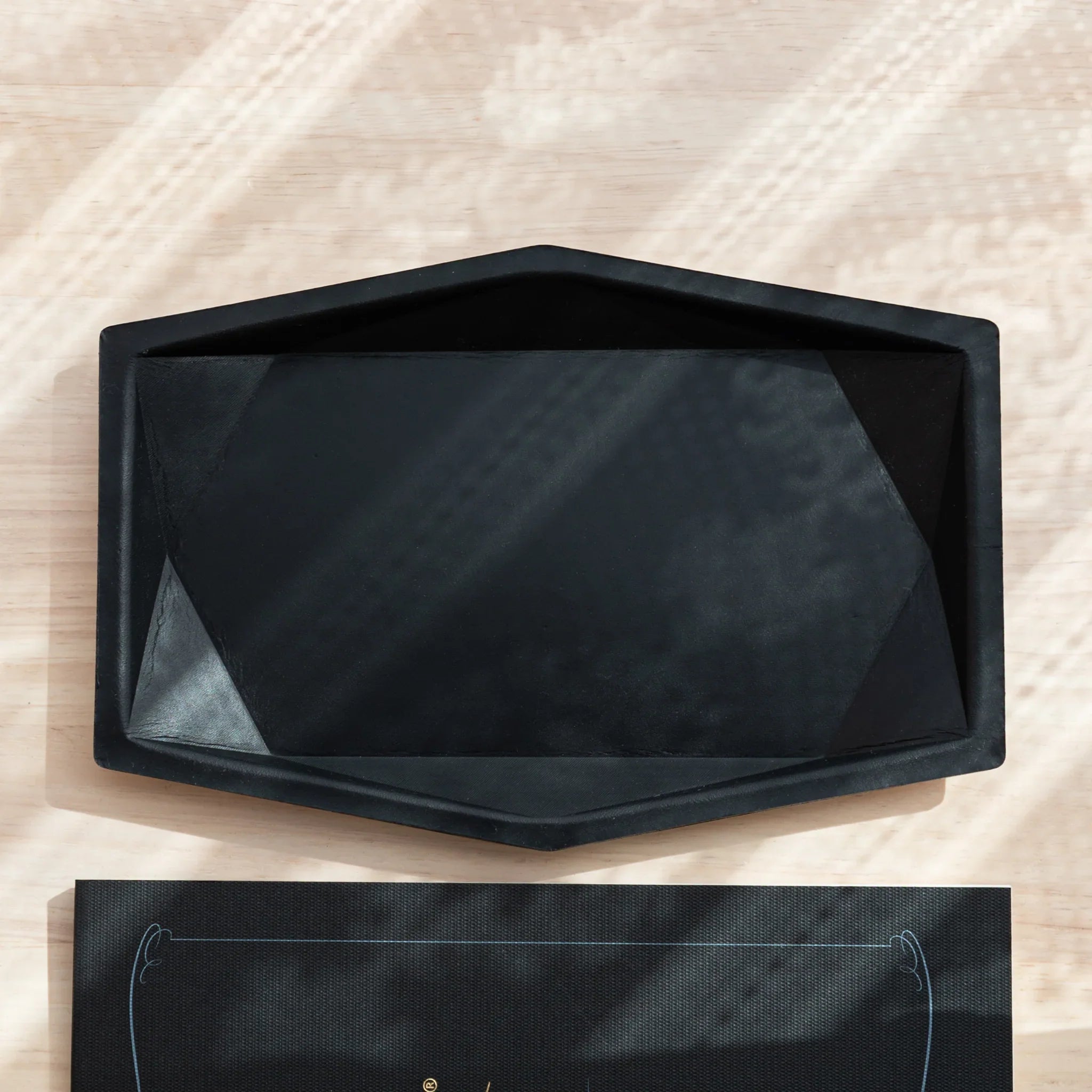 Black hexagonal leather pen tray side profile showing the distinctive hexagonal shape, edges and leather construction