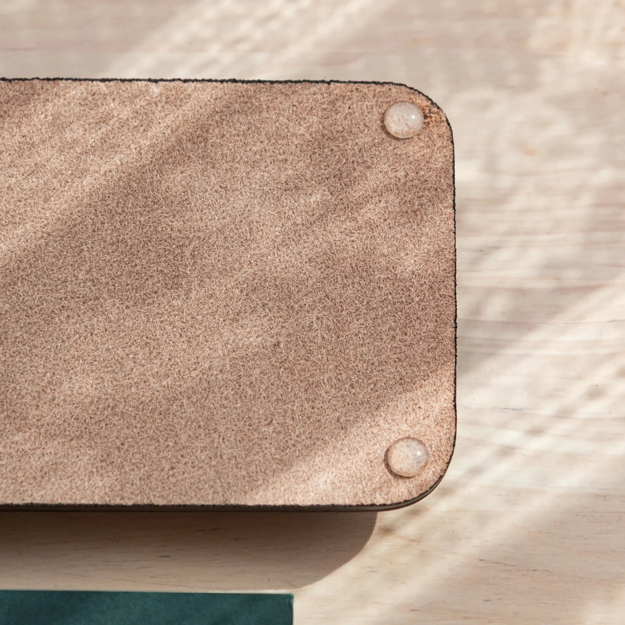 Corner view of suede back of Tatsuno Leather Pen Tray with anti-slip pads.