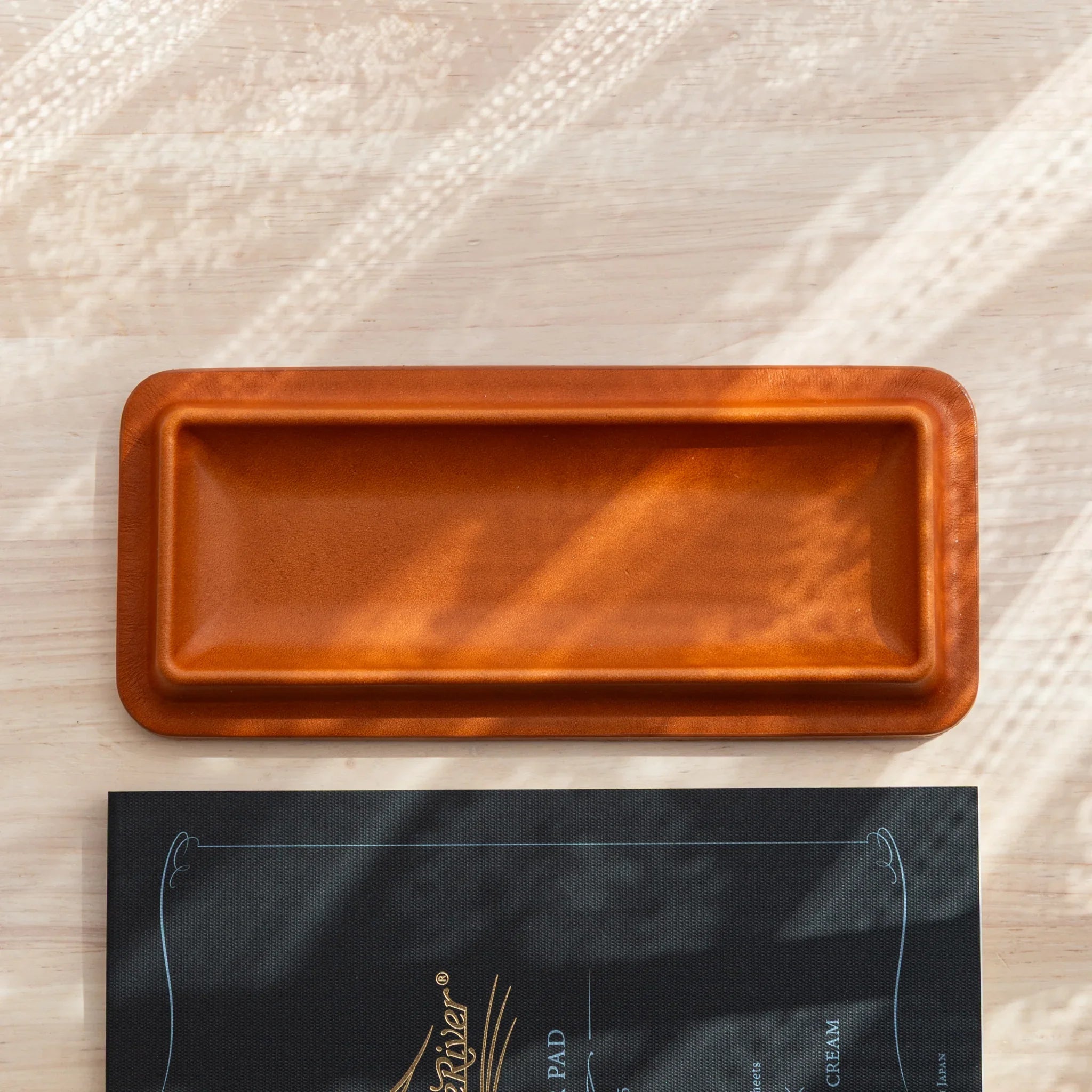 Japanese pen tray made of brown leather with clean edges and a slim rectangular shape.