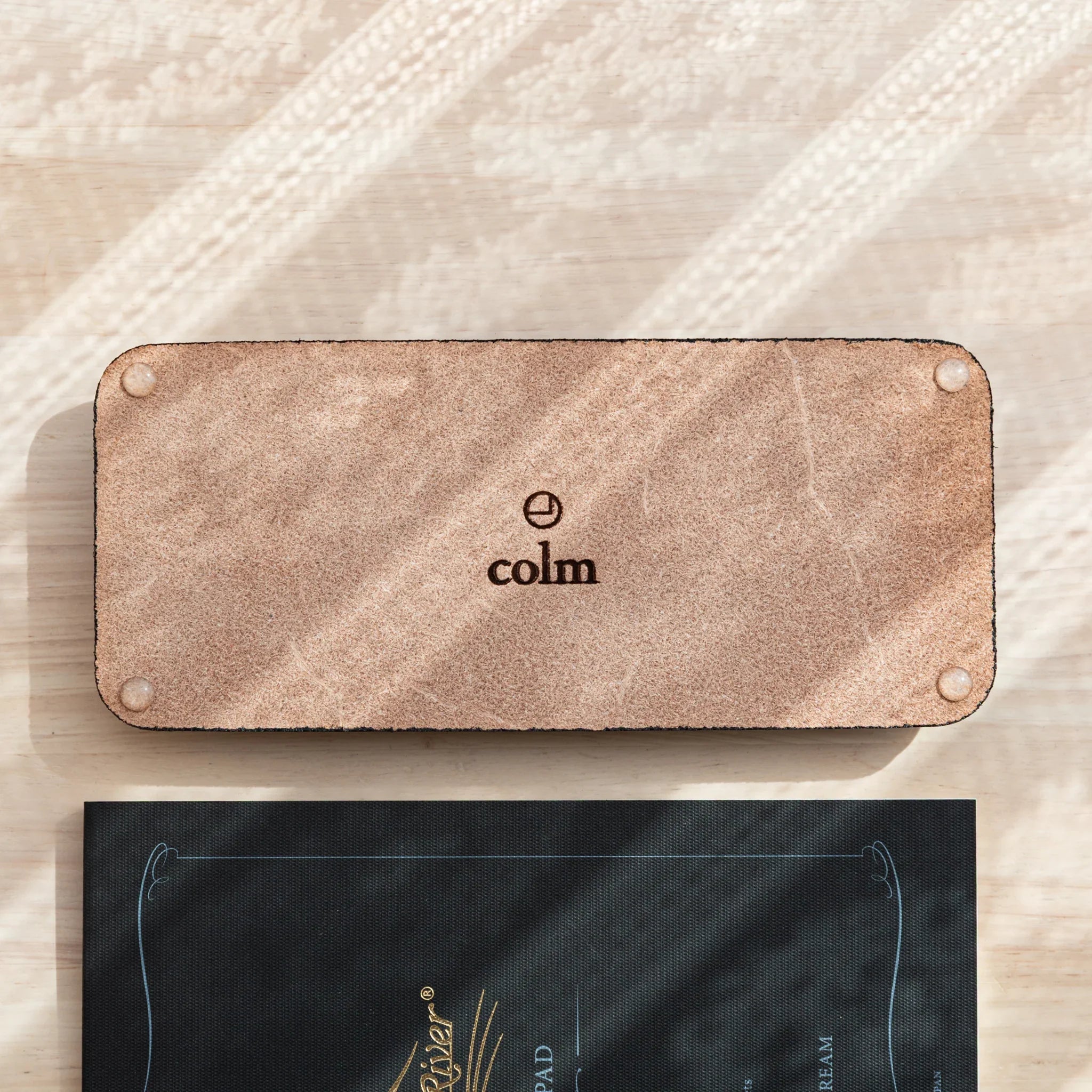Suede base of the Tatsuno Leather Pen Tray Slim with colm branding and non-slip pads.