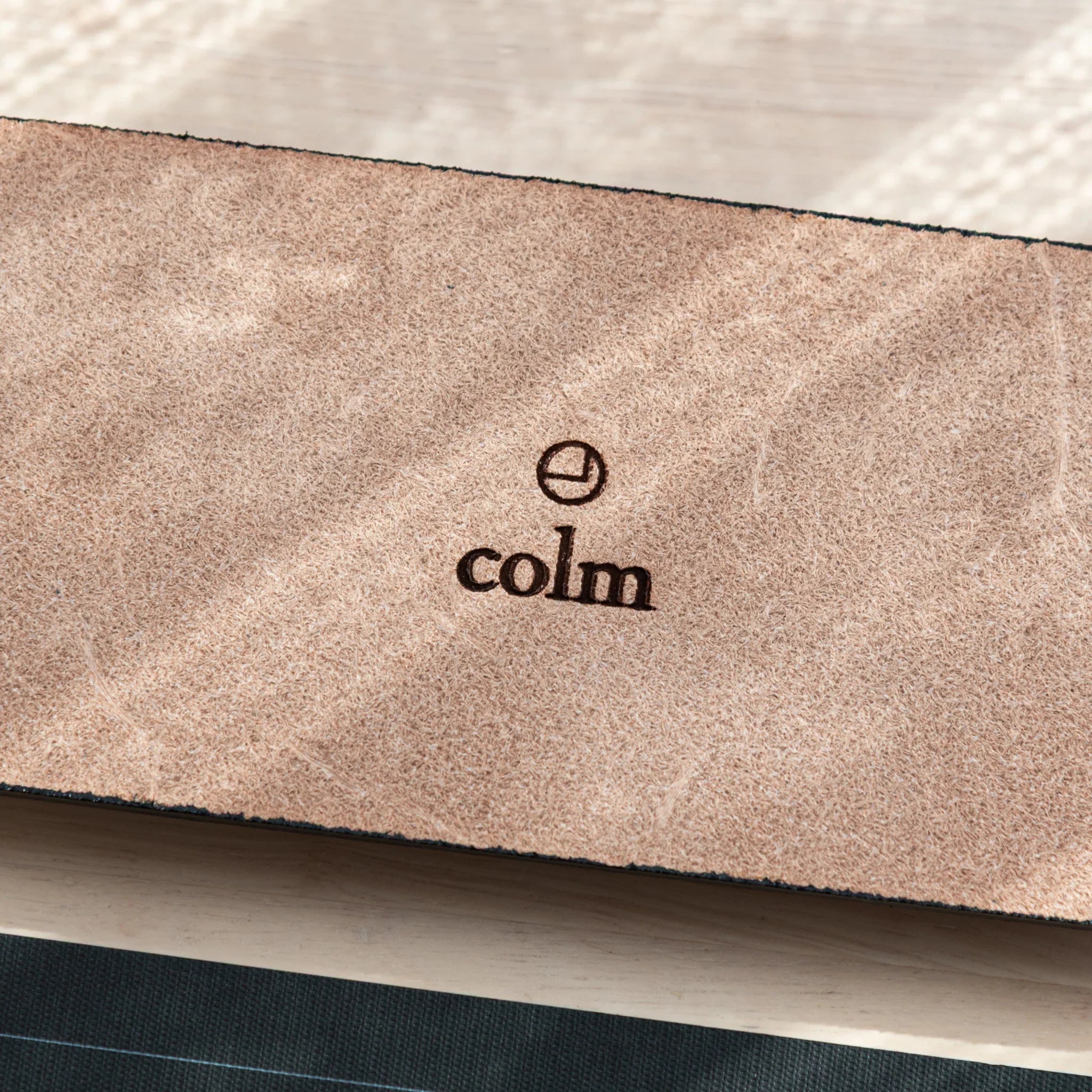 Close-up of colm branding on the suede underside of the Tatsuno Leather Pen Tray Slim.
