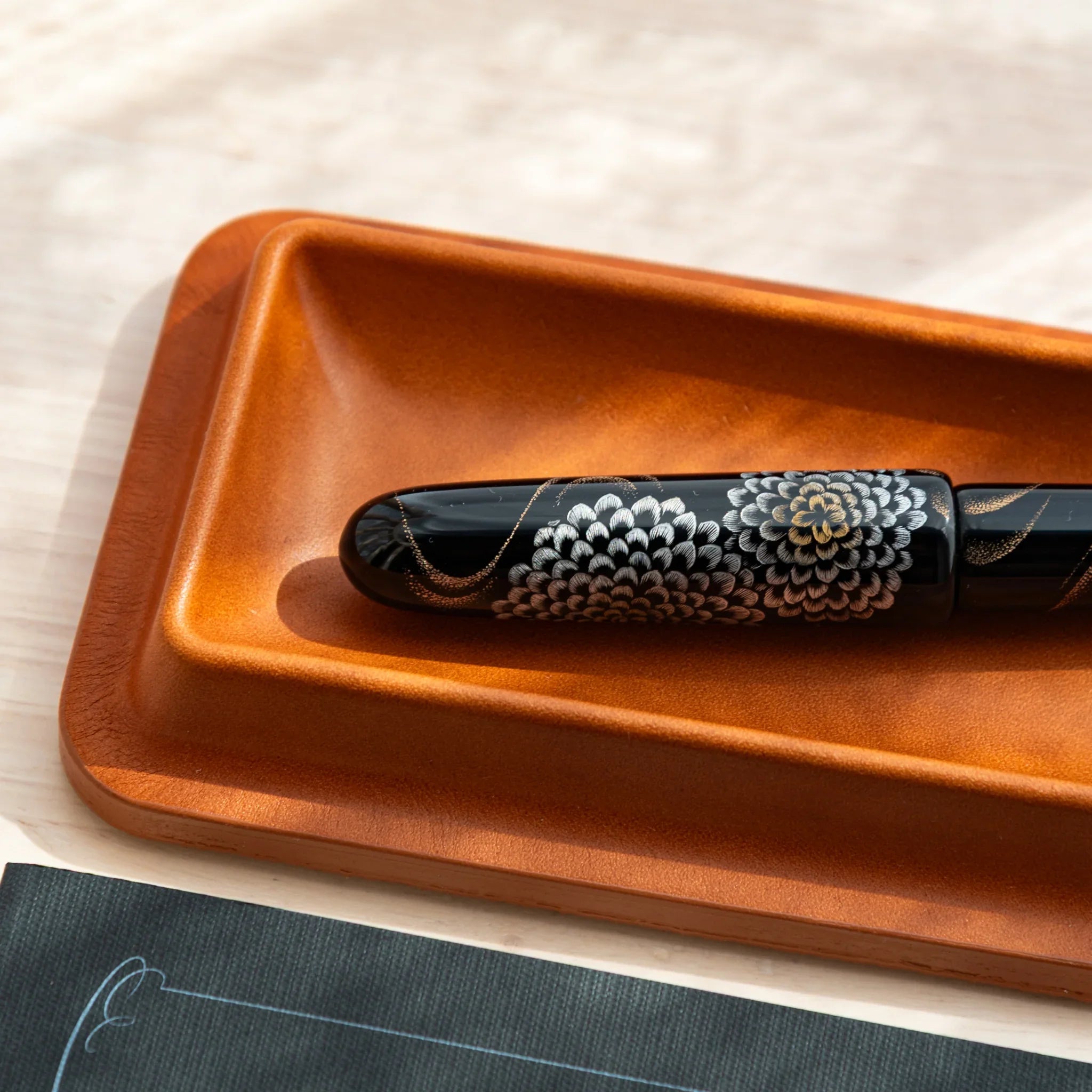 Close-up of a Japanese fountain pen in a brown Tatsuno leather pen tray.