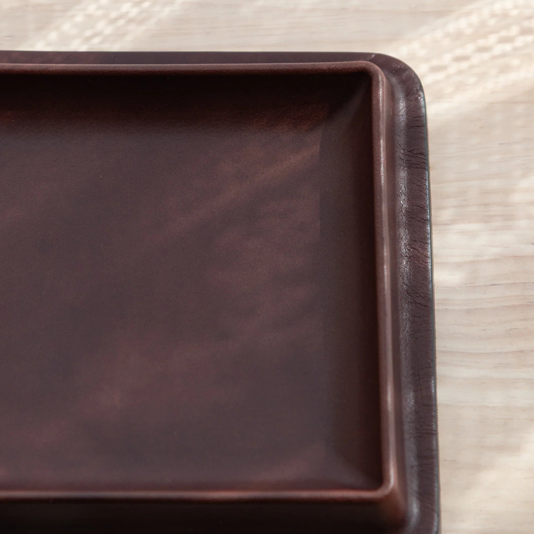 Burgundy wide leather pen tray back showing suede backing material with embossed colm brand logo and maker identification