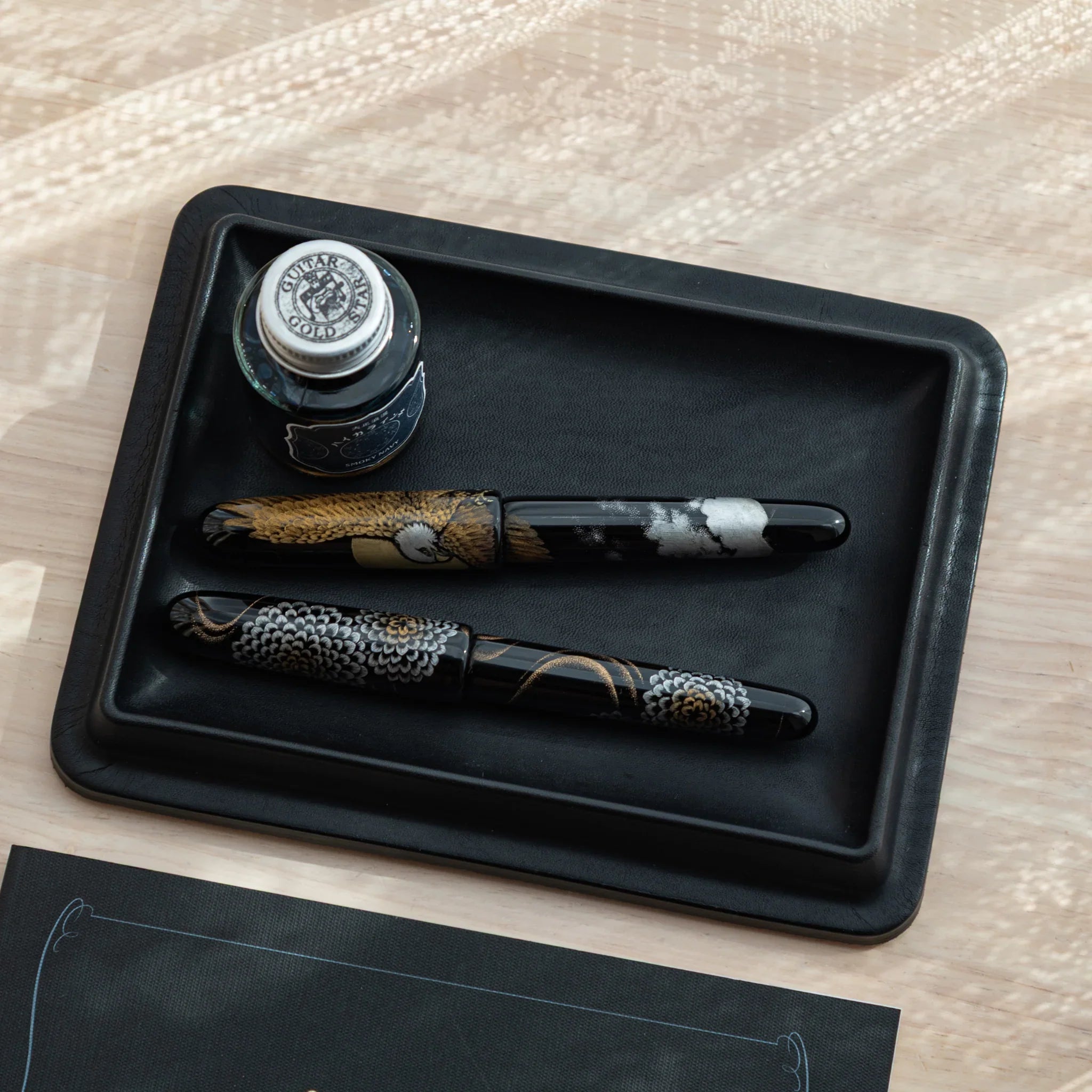 Japanese Pen Tray holding two Japanese fountain pens and ink bottle, top view.