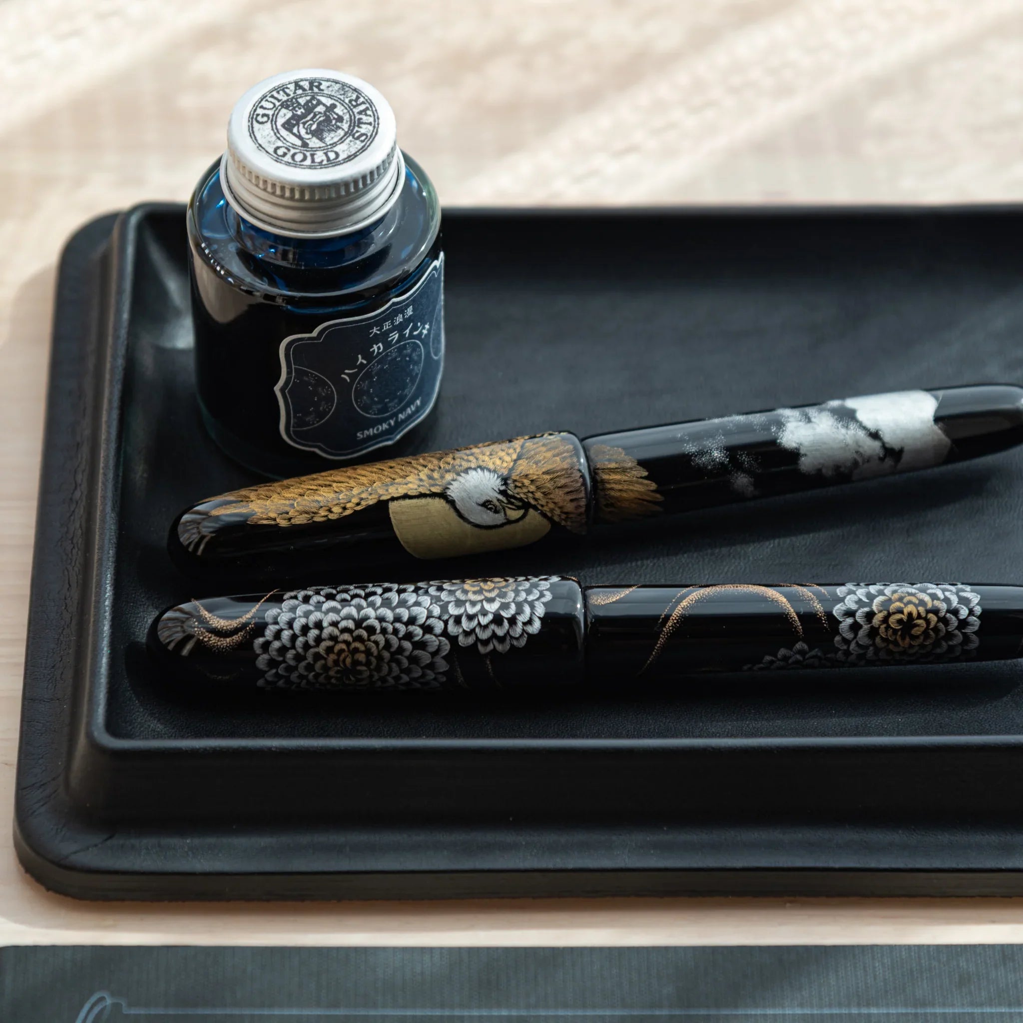 Close-up of black Japanese Pen Tray with ink and decorated Japanese fountain pens.