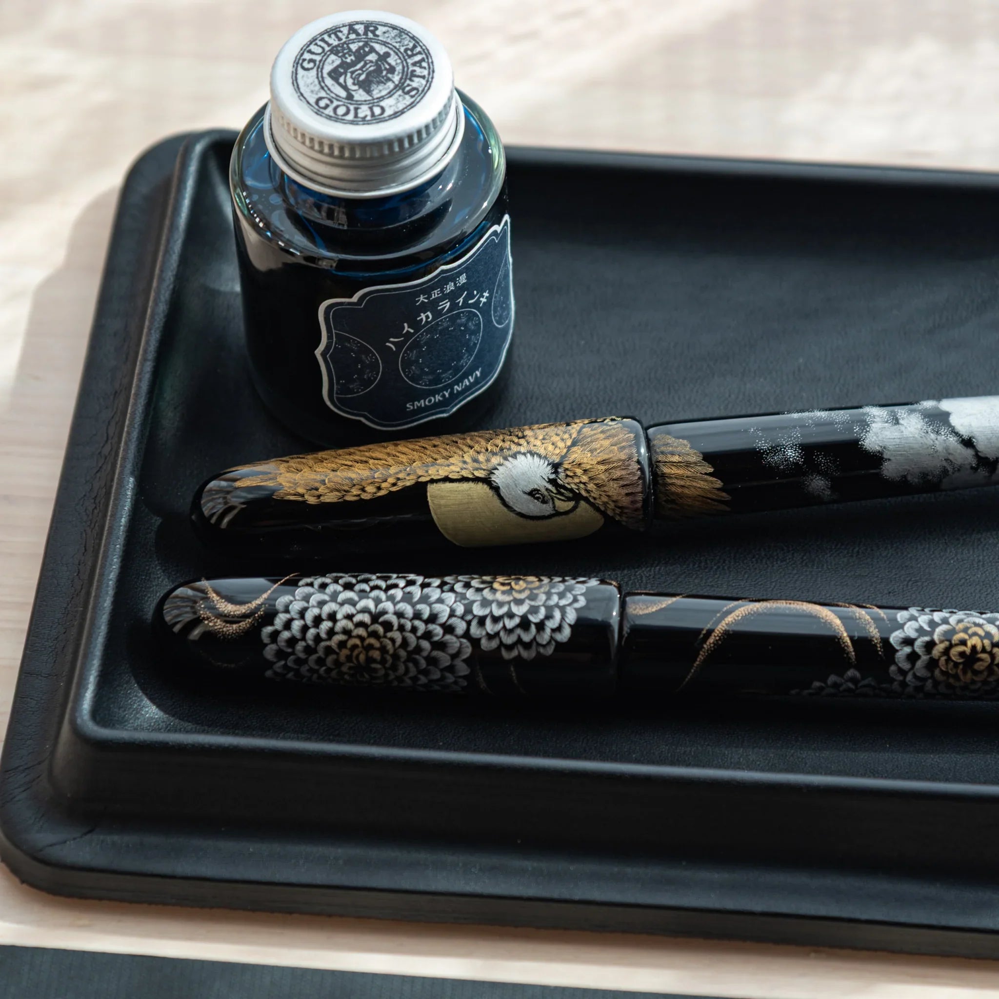 Close-up of black Japanese Pen Tray with ink and decorated Japanese fountain pens.