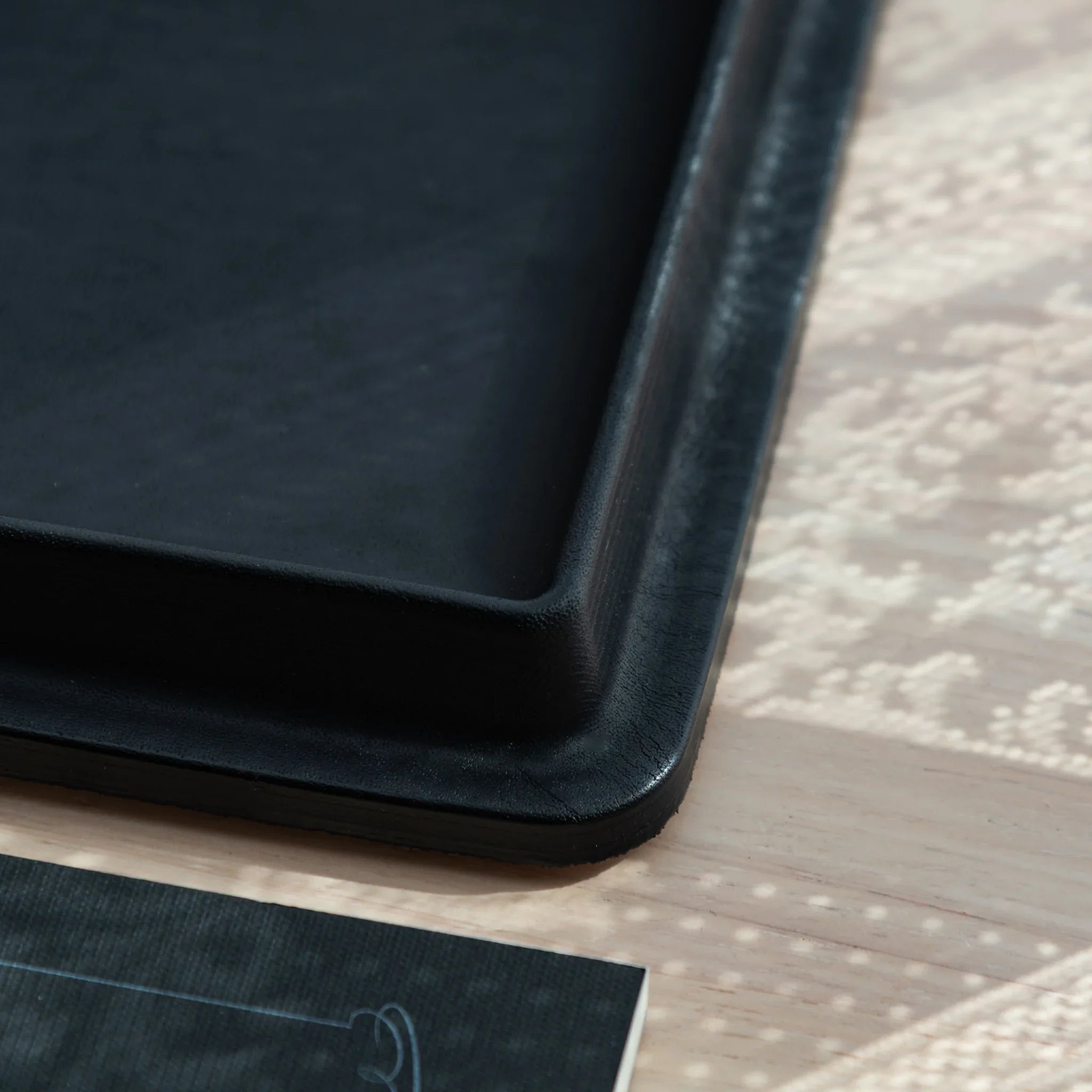 Olive green wide leather pen tray from side profile displaying the curved contoured structured leather design clearly