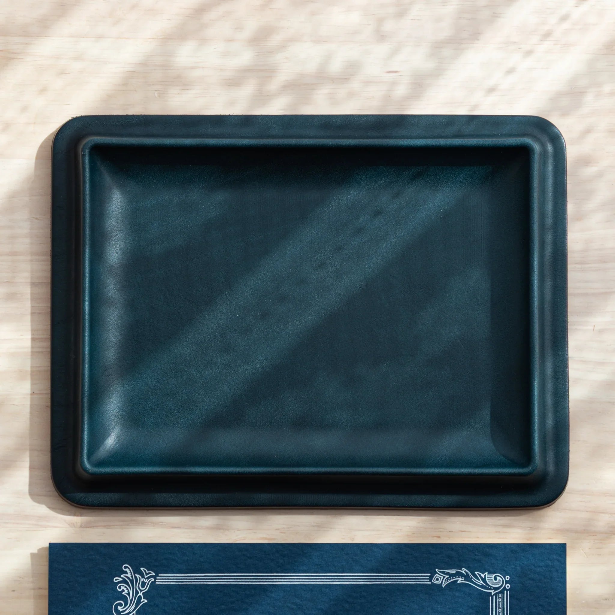 Teal wide leather pen tray back view revealing tan suede lining with embossed colm brand logo and maker mark