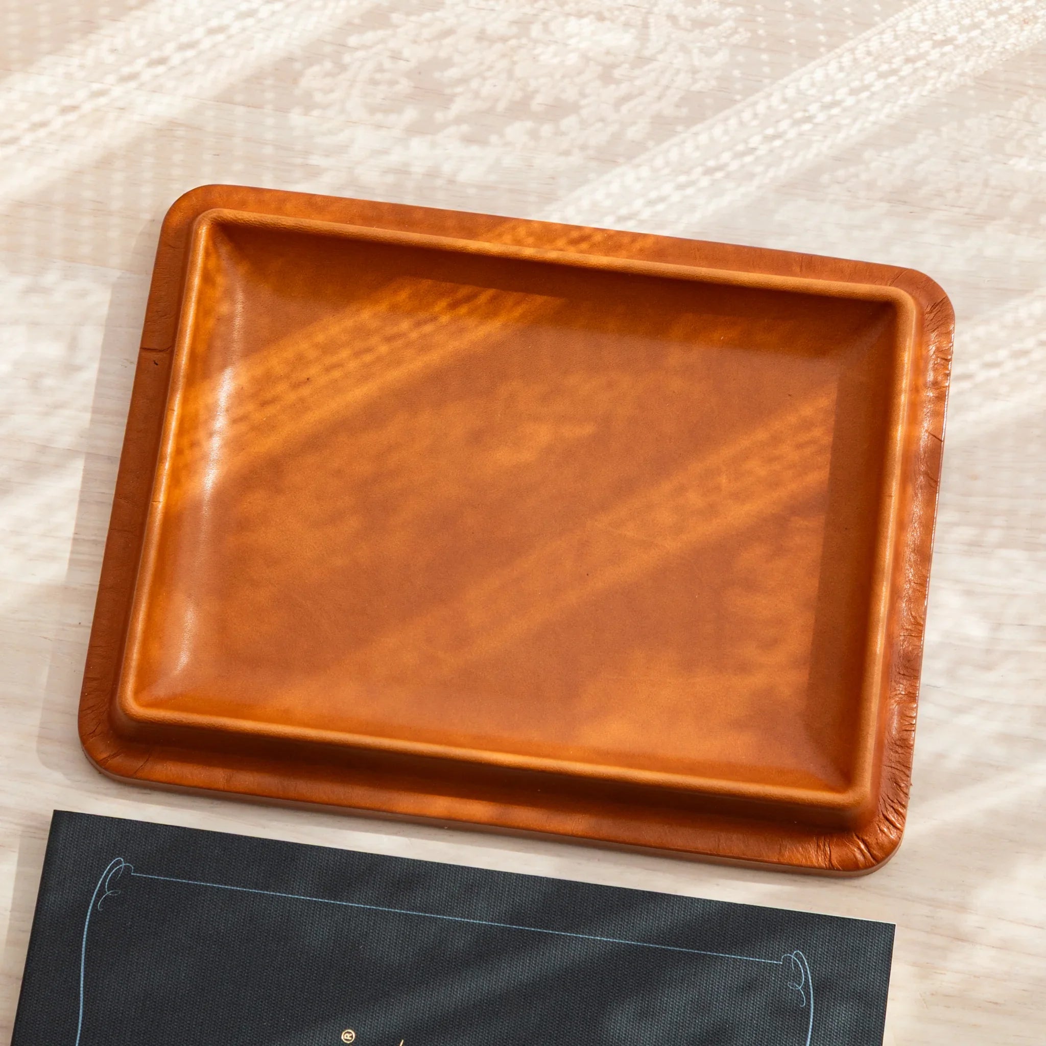 Japanese Pen Tray in camel leather displayed empty on a wooden surface.