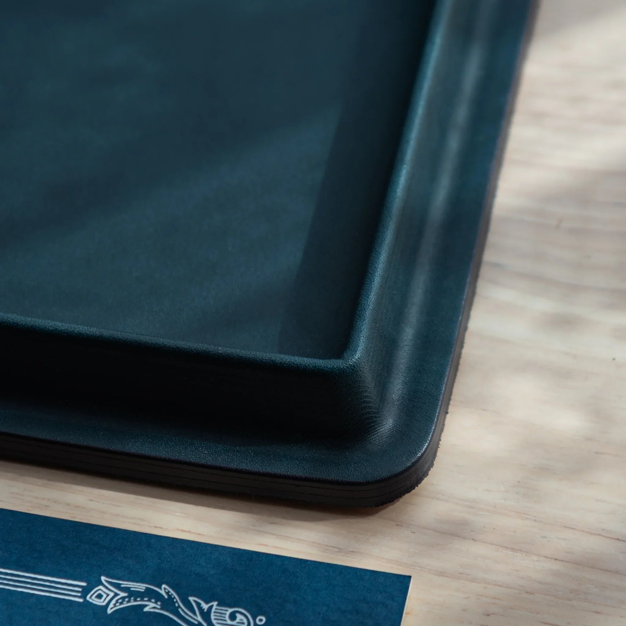 Close-up macro detail shot of teal leather exterior surface texture paired with inner tan suede material contrast