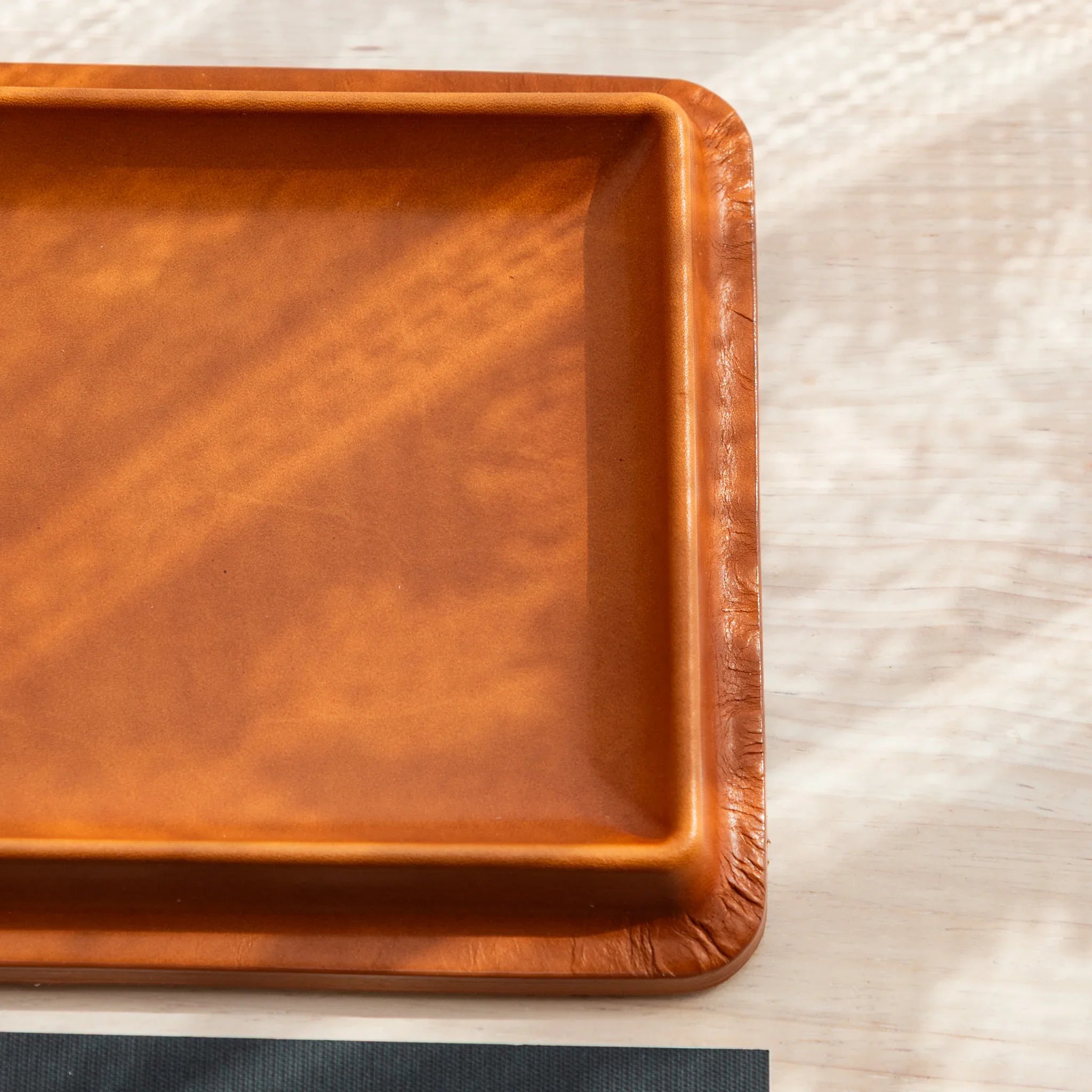 Wide leather pen tray rear showing complete suede backing material with embossed brand logo identification marking