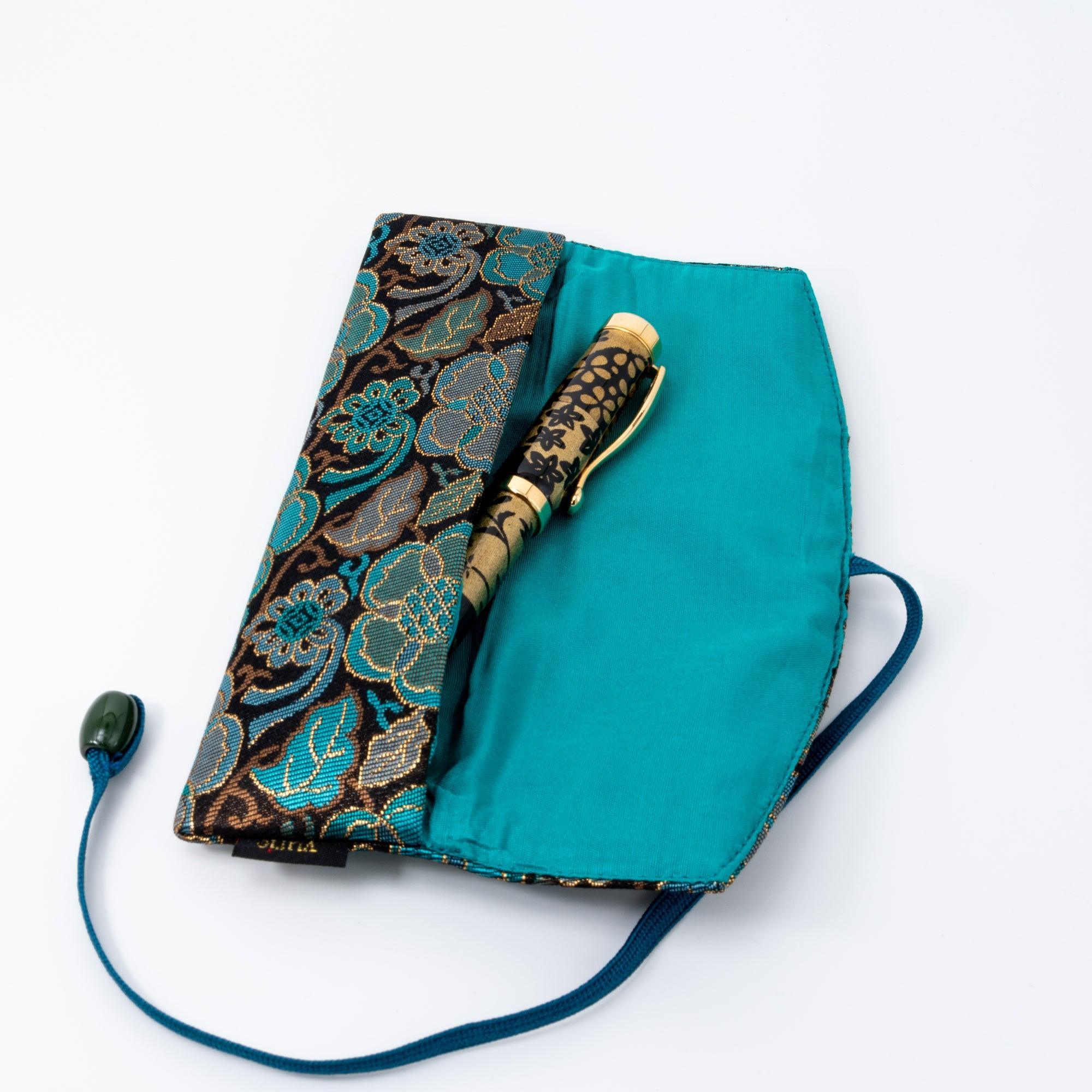 A teal and gold Japanese fountain pen case of Nishijin silk, open to reveal a turquoise interior and a gold-patterned fountain pen.