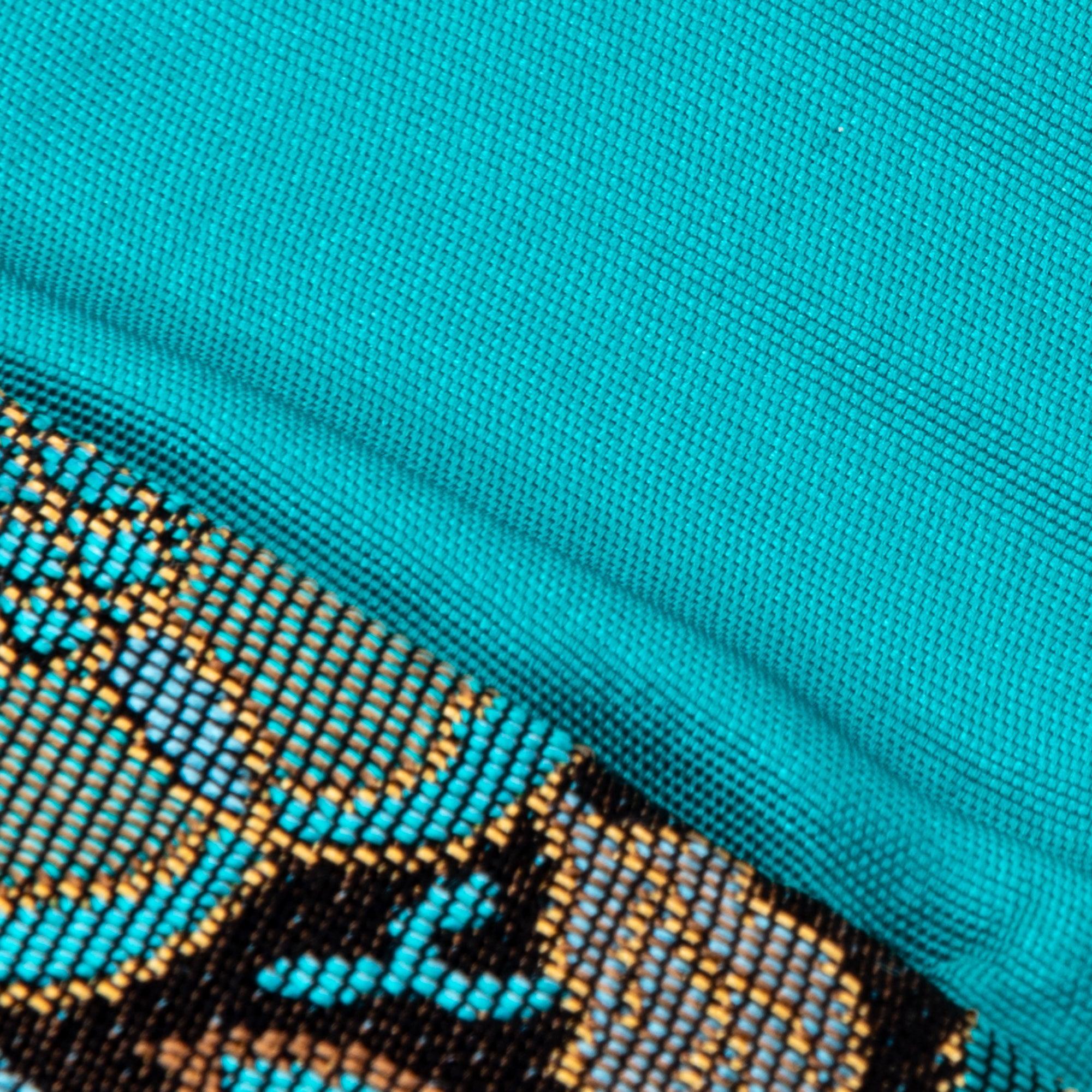 A close-up of the turquoise interior fabric of a Japanese fountain pen case, showing its smooth and vibrant texture.
