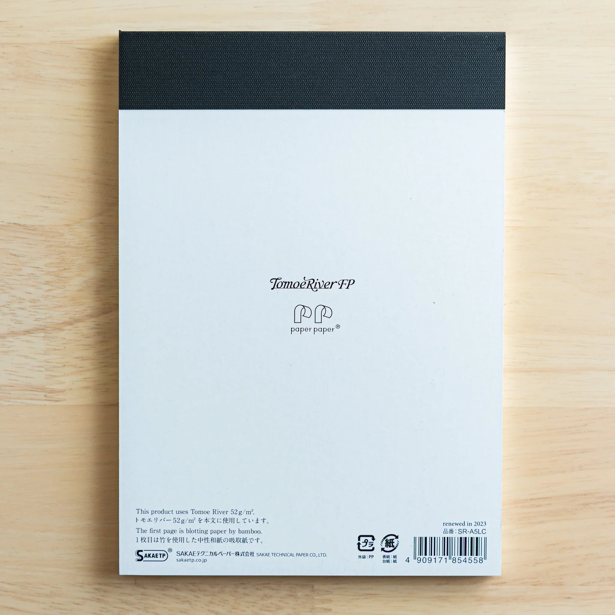 Back cover featuring navy fabric binding with elasticated closure band and printed product information with barcode