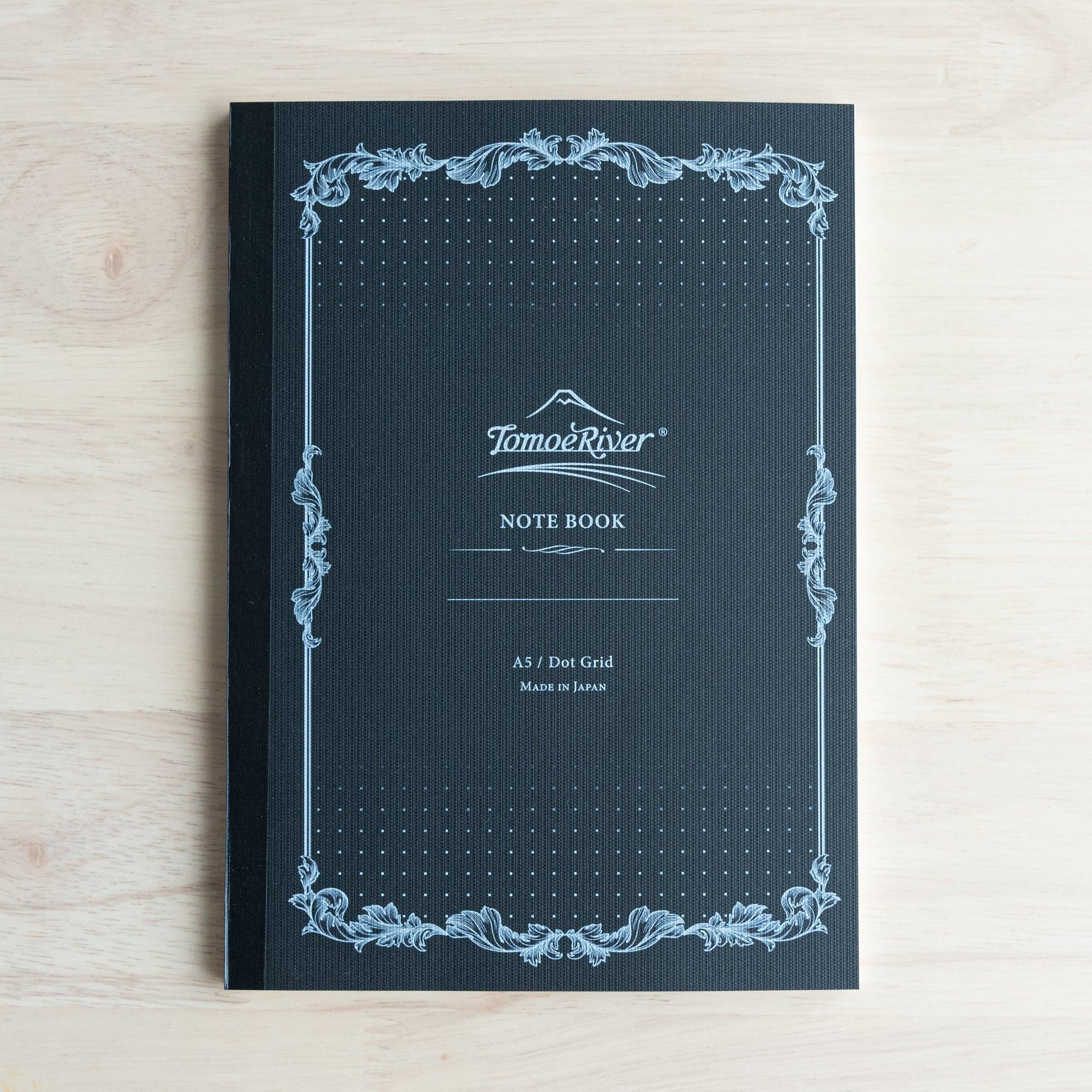 The front cover of a Tomoe River notebook with decorative borders and "A5 / Dot Grid, Made in Japan" printed on it.