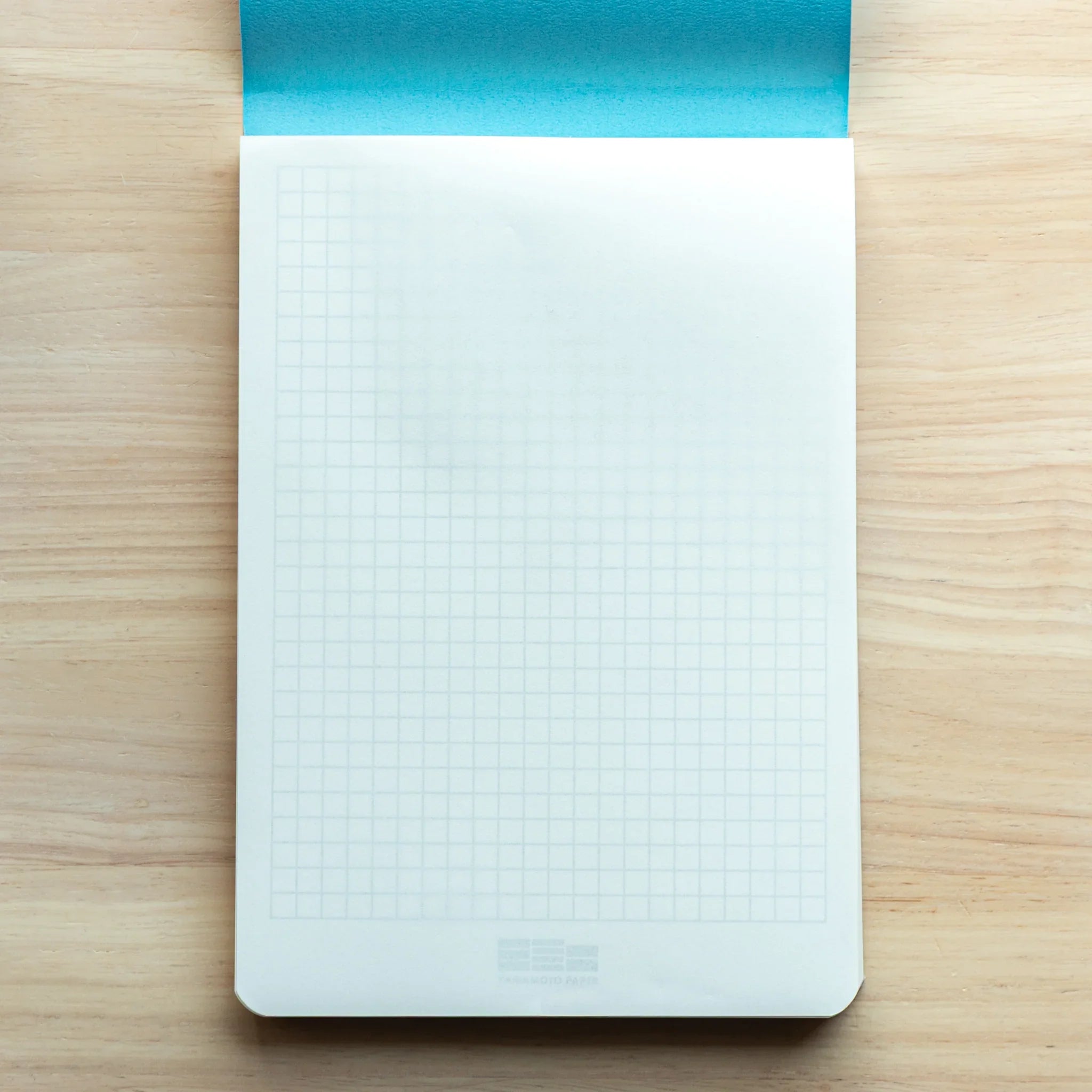 Tomoegawa Tomoe River A5 Japanese Writing Pad shown with grid guide sheet for structured and organized writing.