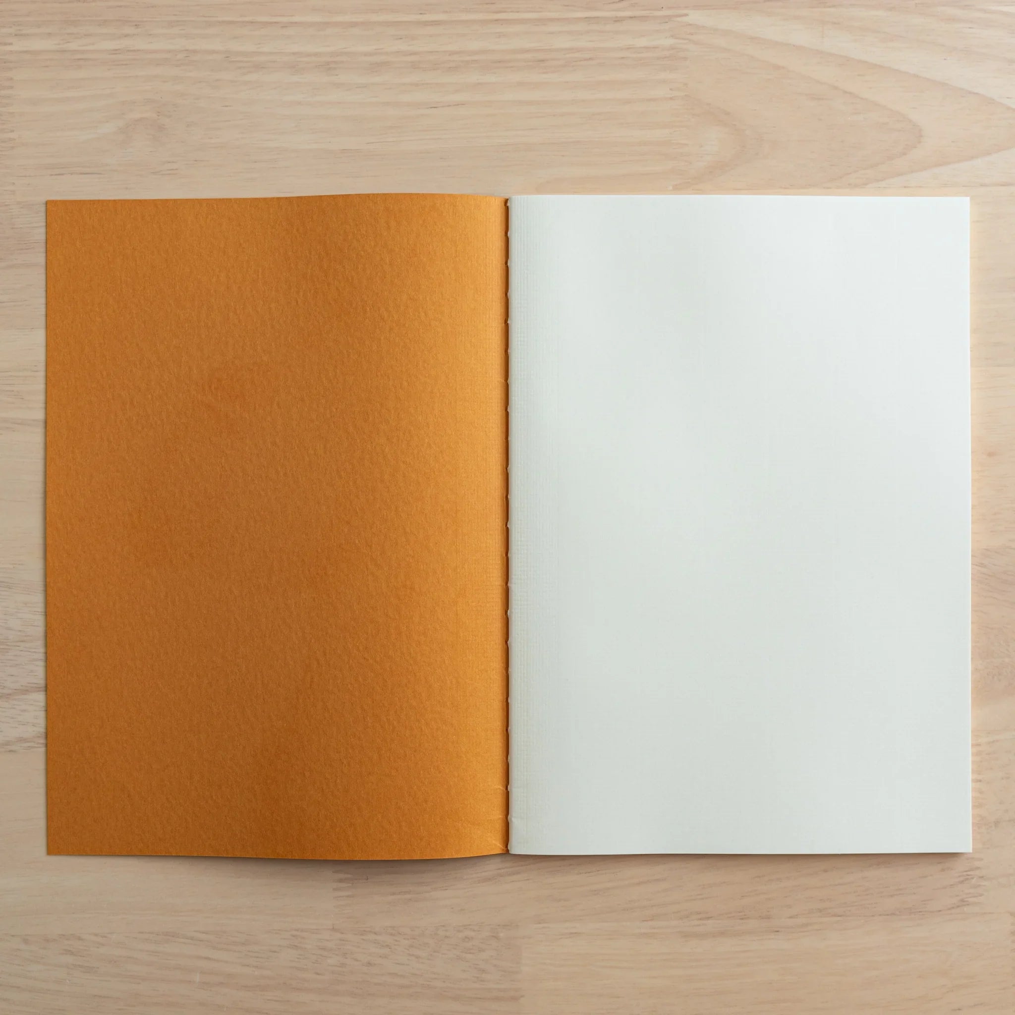 Tsubame Fools Cream Notebook pages fanned open displaying consistent grid pattern across cream interior pages