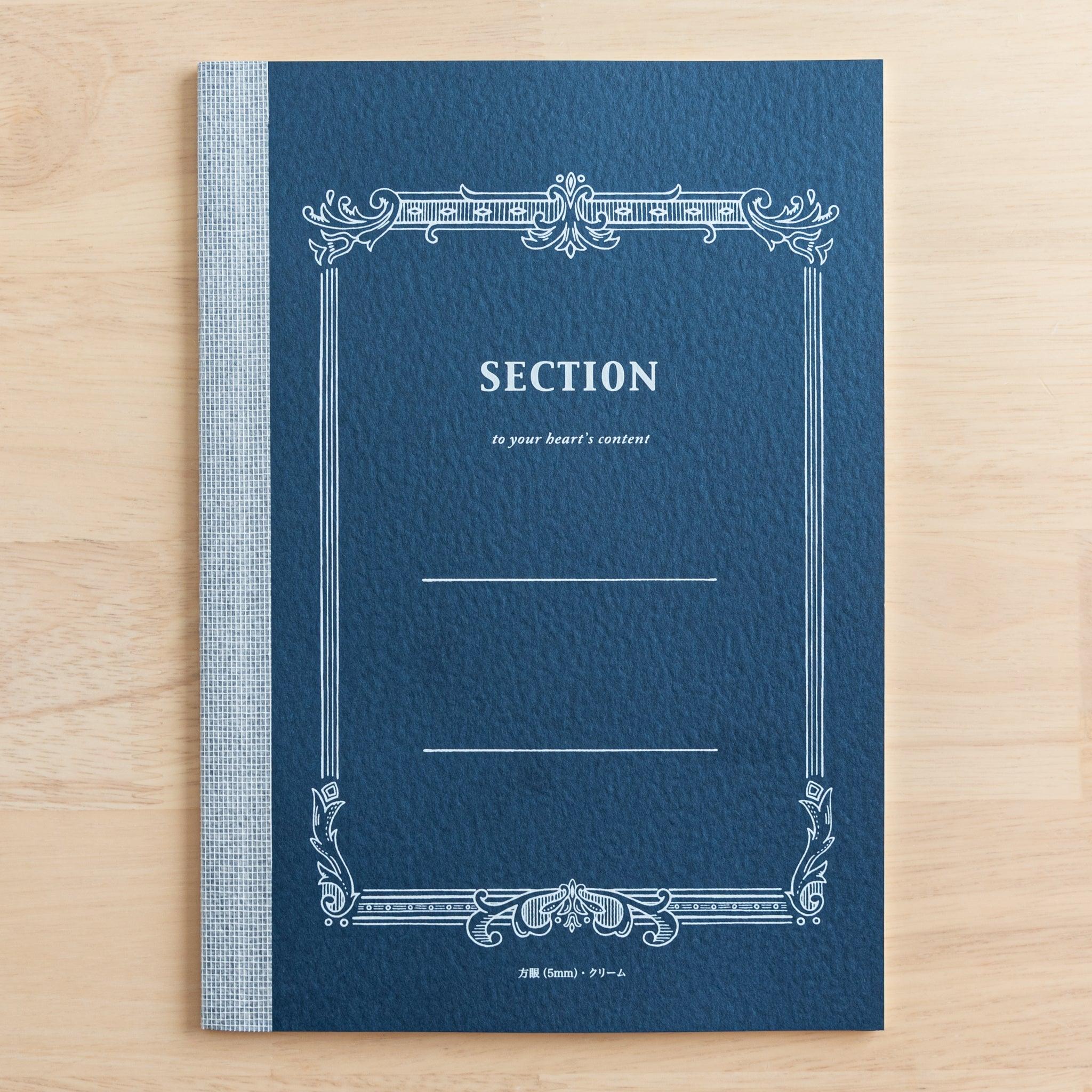 A Tsubame Japanese notebook with a navy blue cover labeled "Section," featuring an ornate vintage-style design. A refined piece of Japanese stationery.