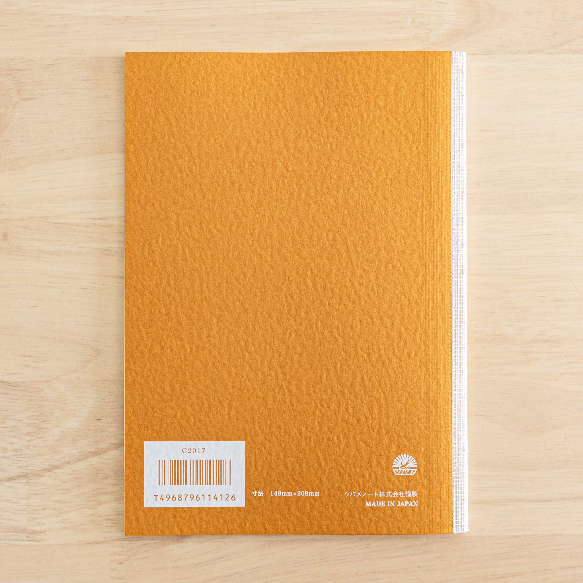 The back cover of a Tsubame Japanese notebook with an orange textured finish, barcode, and "Made in Japan" label. A classic piece of Japanese stationery.