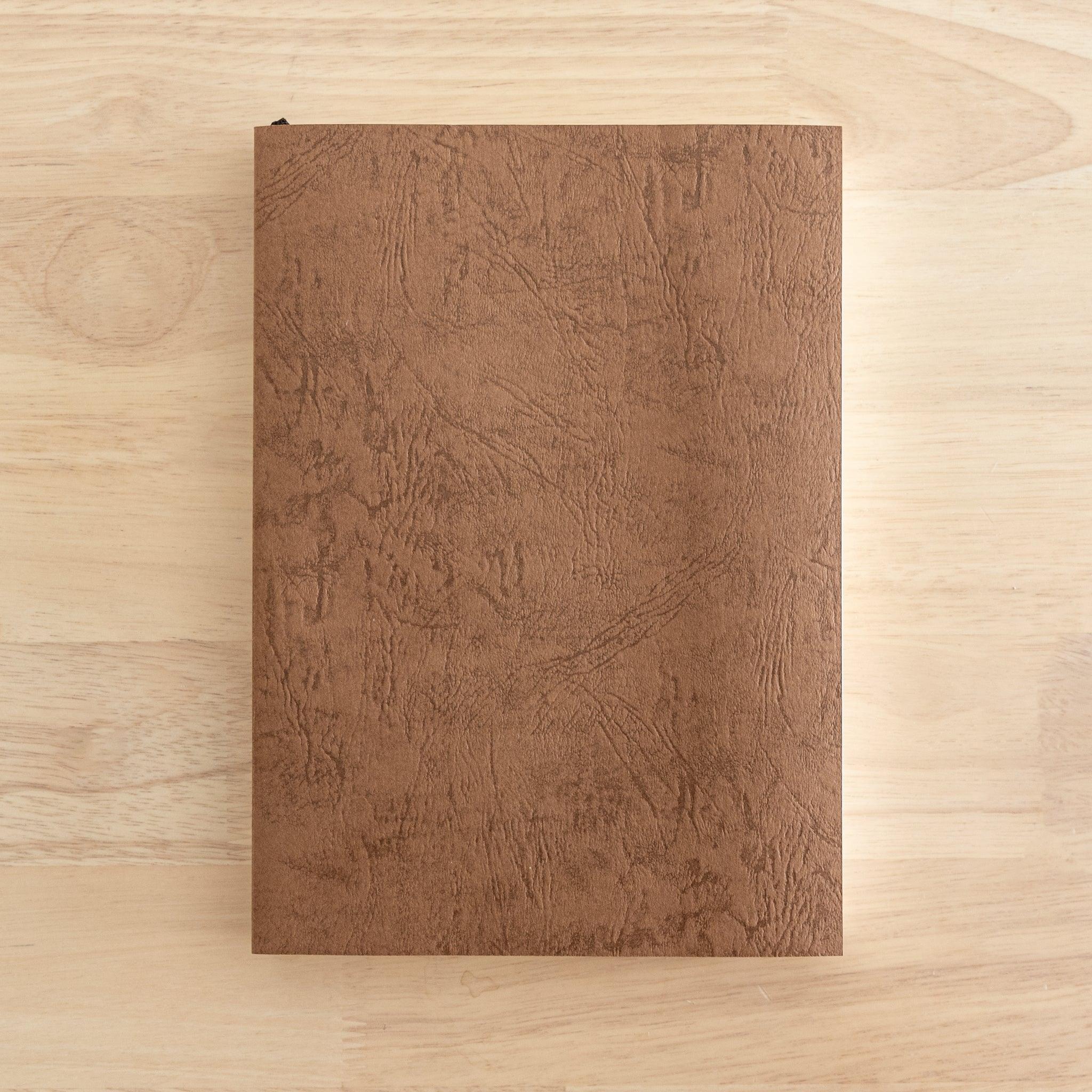 Tsubame Japanese notebook, Premium Thick model. A high-quality Japanese stationery item with a brown textured cover, placed on a wooden surface.